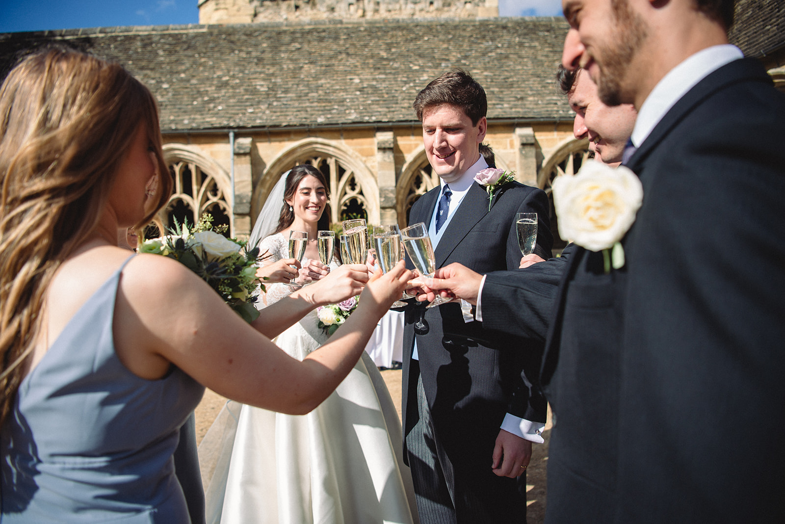Katherine and Damien giving a toast with guests outside the New College Chapel