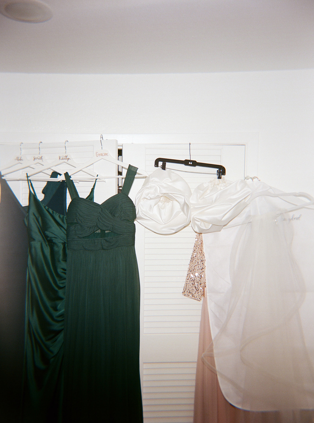 the bridal party dresses hanging up with the bride's dress taken on film