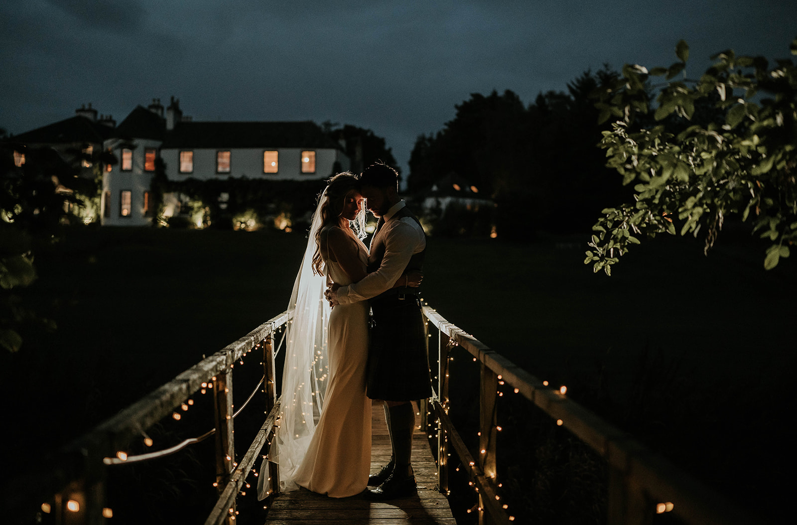 A COUPLE ON THE BRIDGE IN THE EVENING AT LOGIE COUNTRY HOUSE