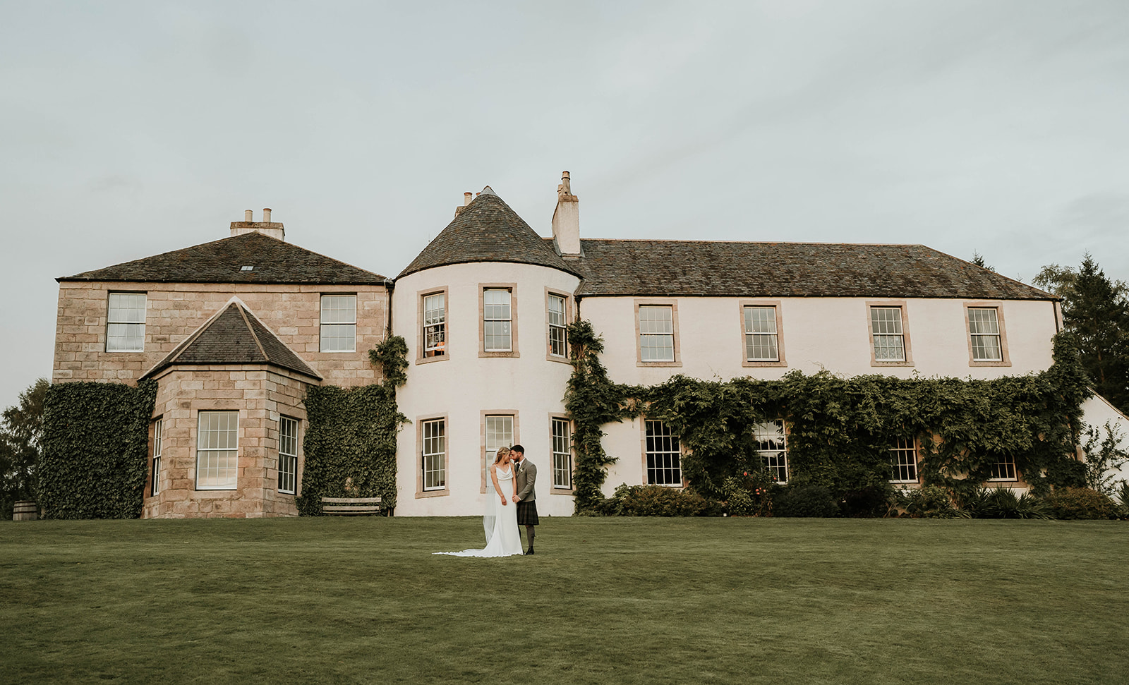 A COUPLE STANDING IN FRONT OF THEIR WEDDING VENUE LOGIE COUNTRY HOUSE