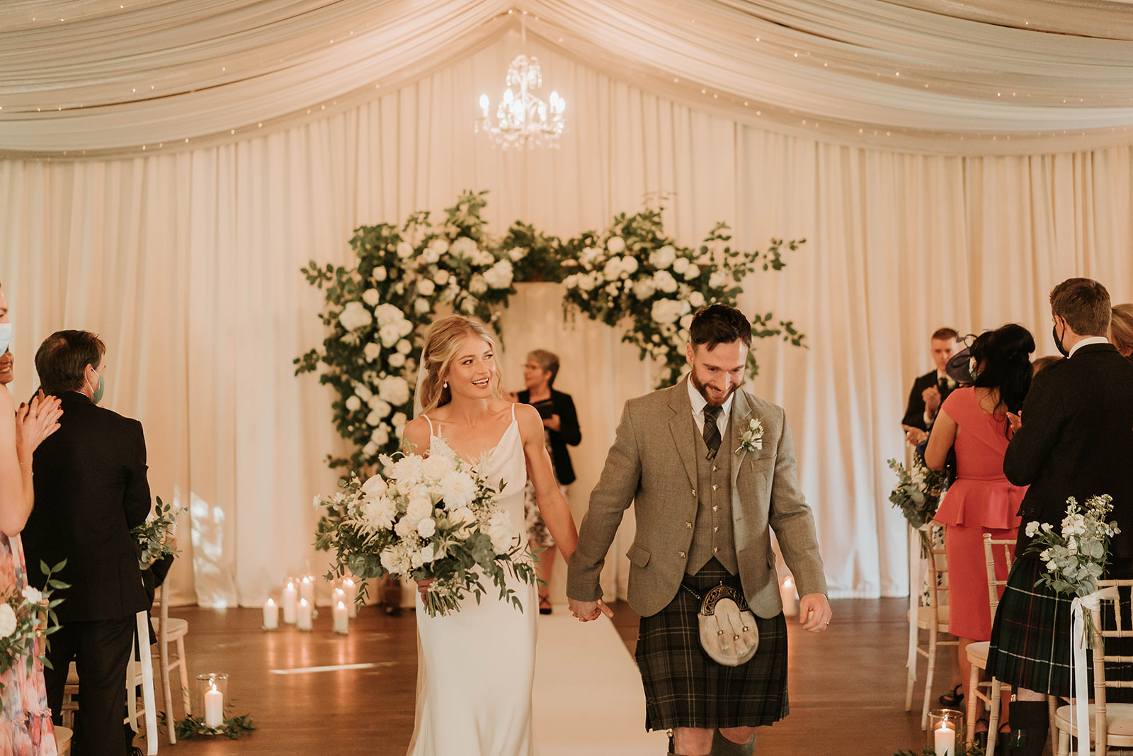 A COUPLE WALKING DOWN THE AISLE FROM GETTING MARRIED AT LOGIE COUNTRY HOUSE
