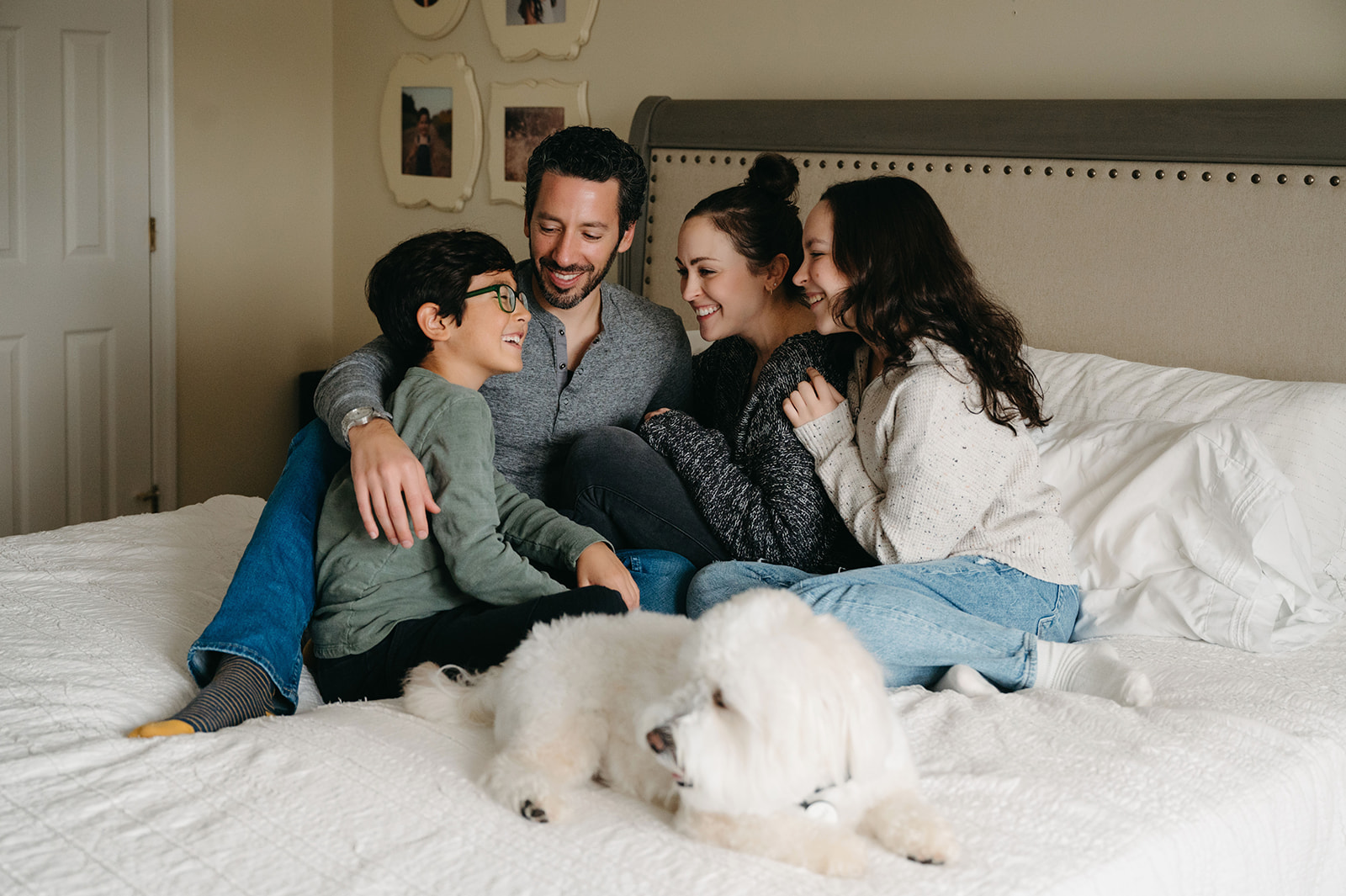 Family of four sitting on bed in their Pittsburgh home with dog