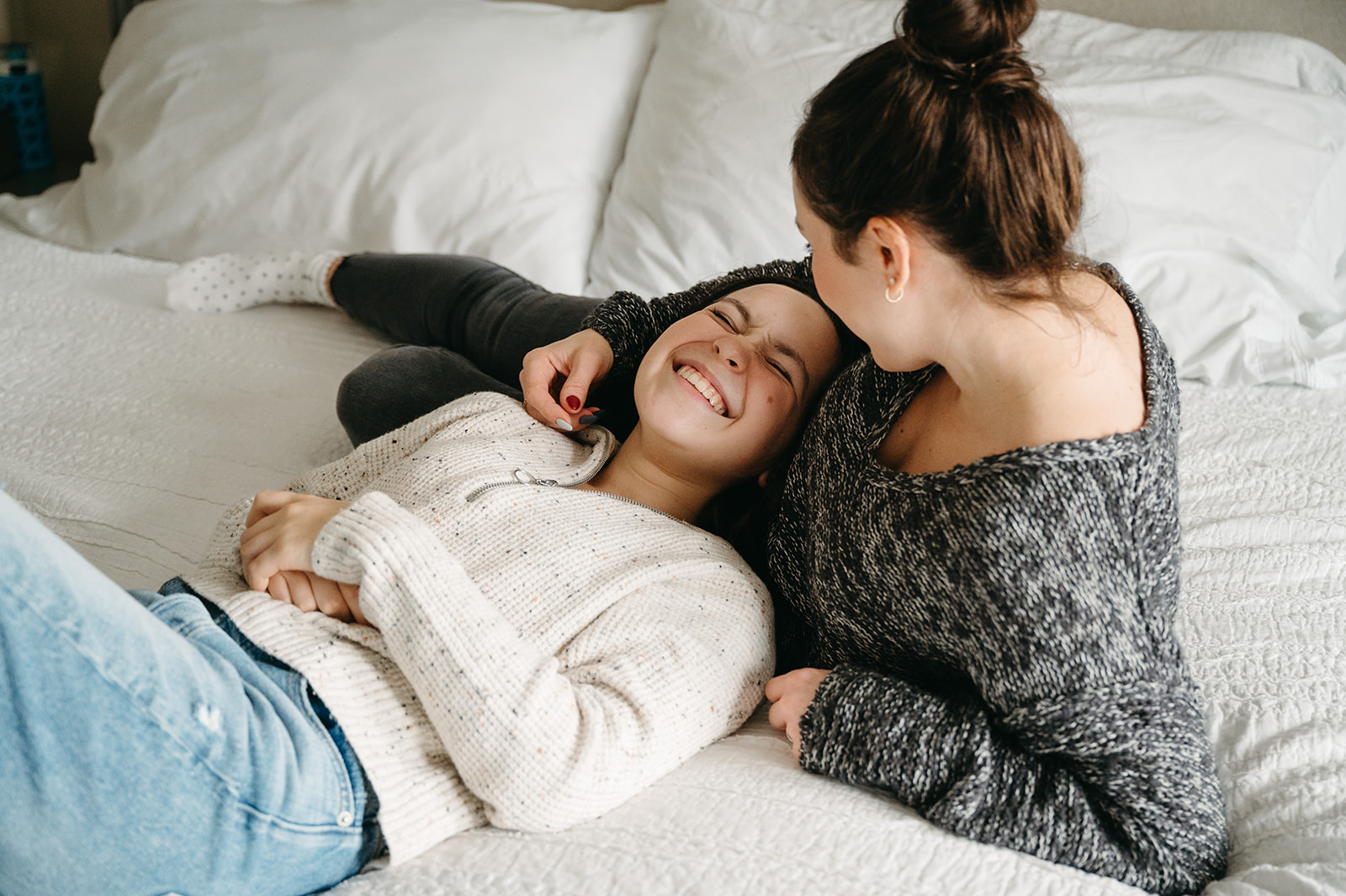 A loving family between with mom and daughter  hugging on a bed