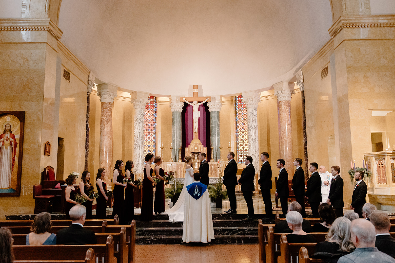 Bride and groom with their wedding party standing at the front of a church