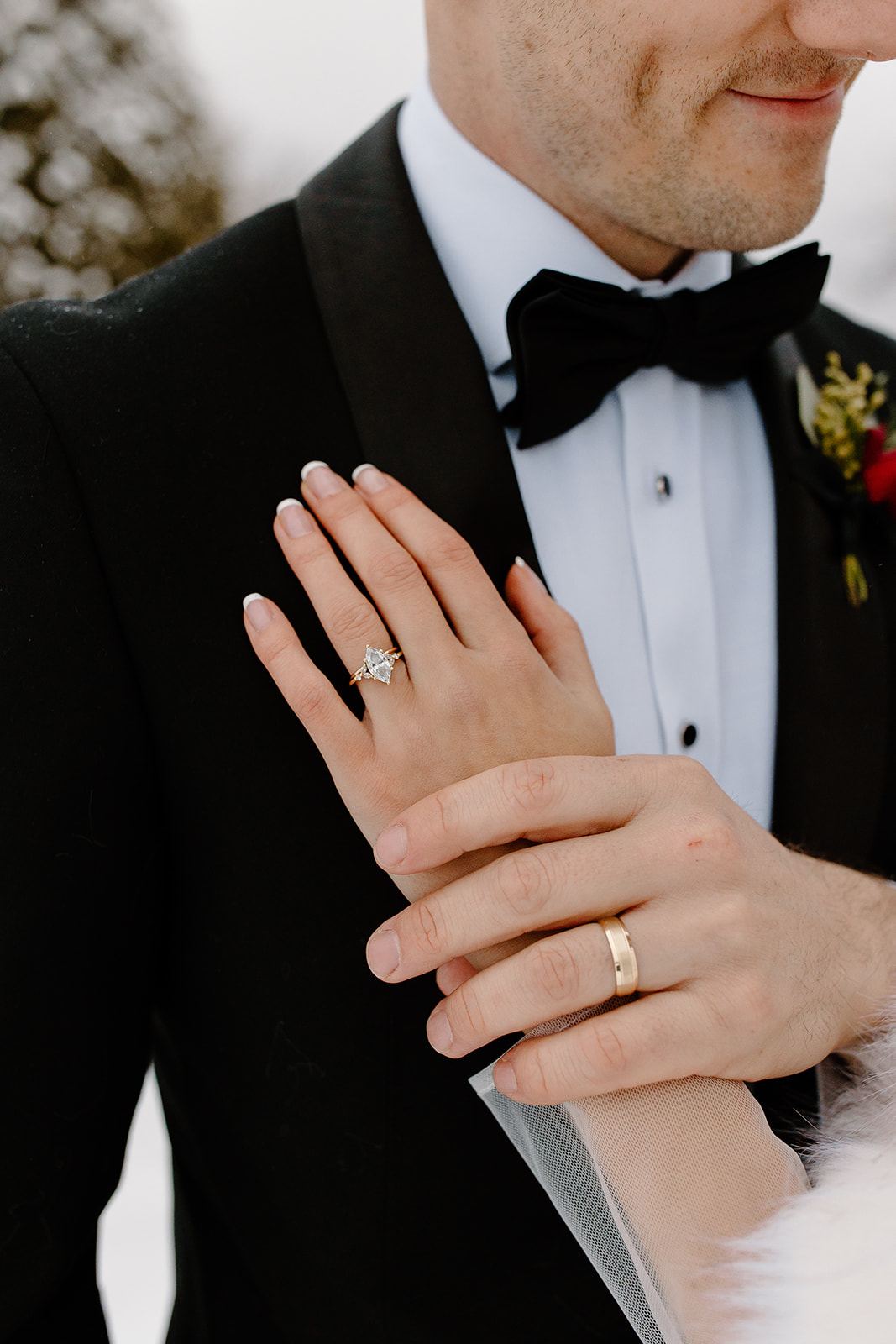 Hands with rings on groom's chest