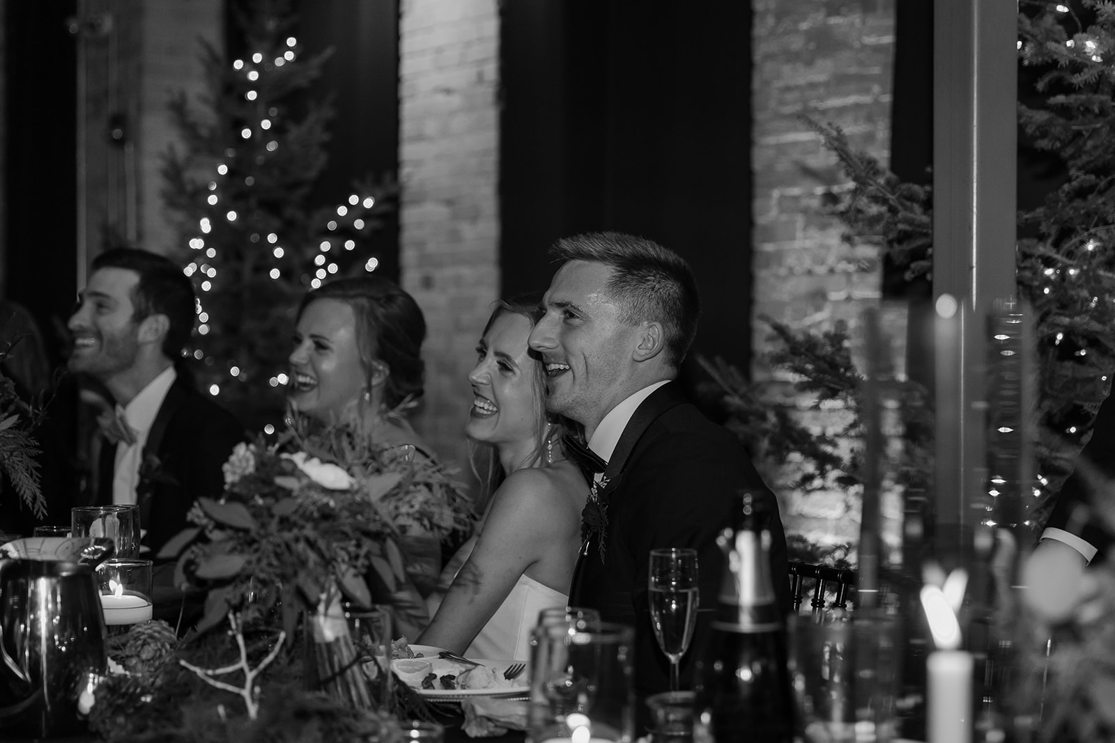 Bride and groom laughing during dinner