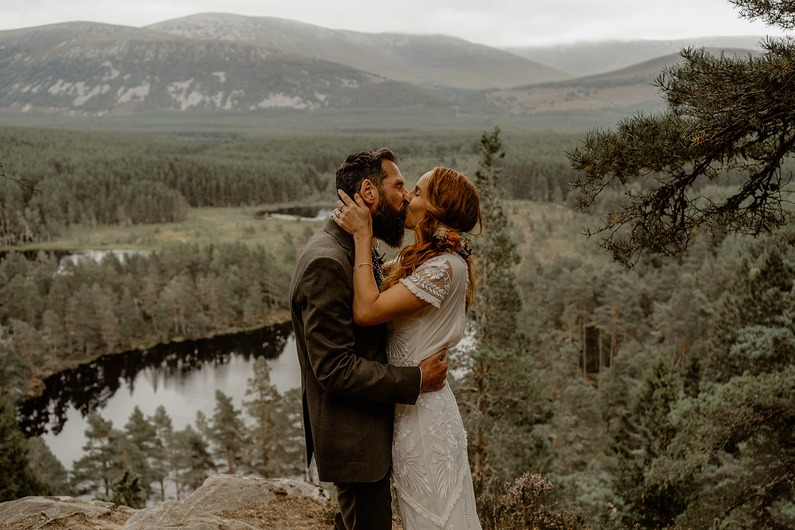 Bride and groom have first kiss during their elopement with Scottish Lochs and Mountains in the background