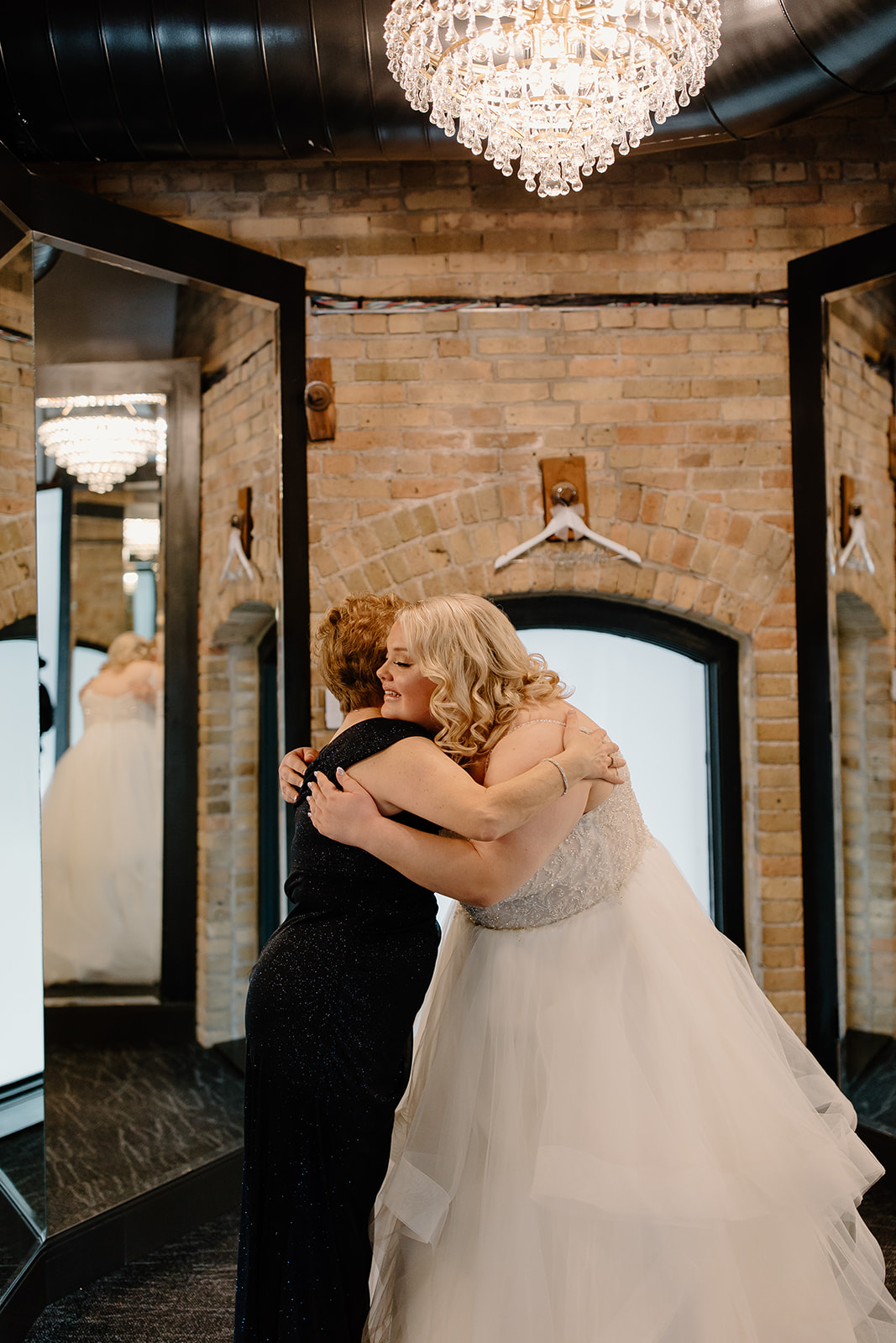 Mother of the bride and bride hugging
