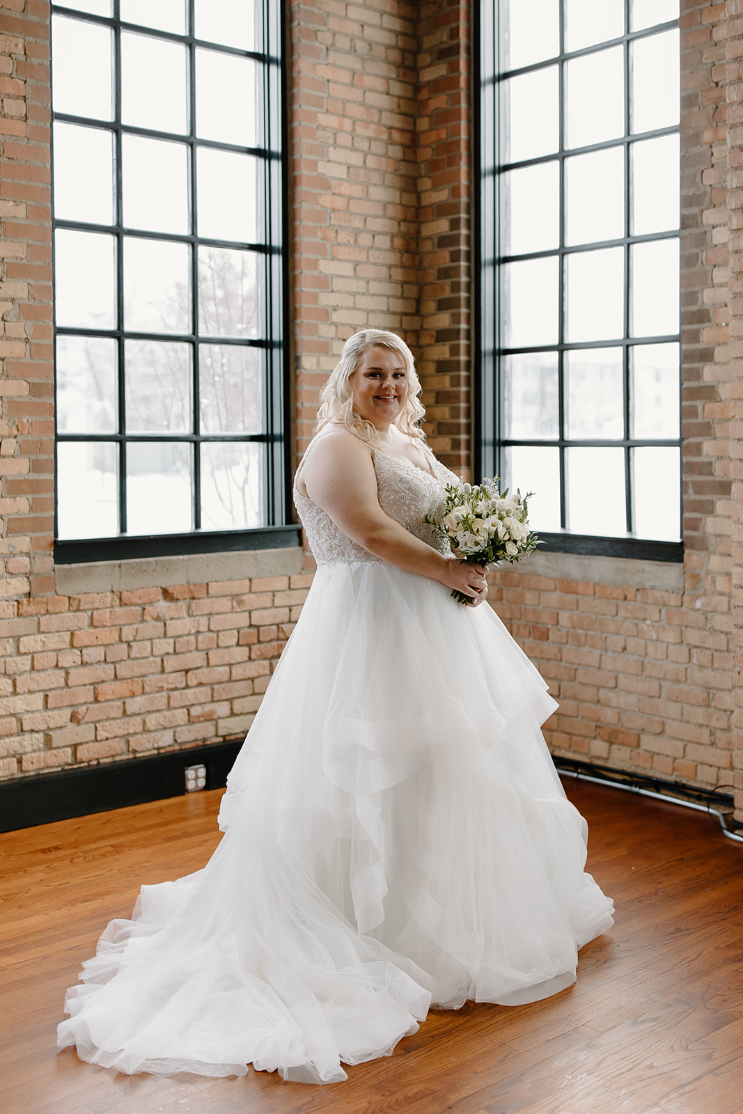 Bride smiling in front of windows