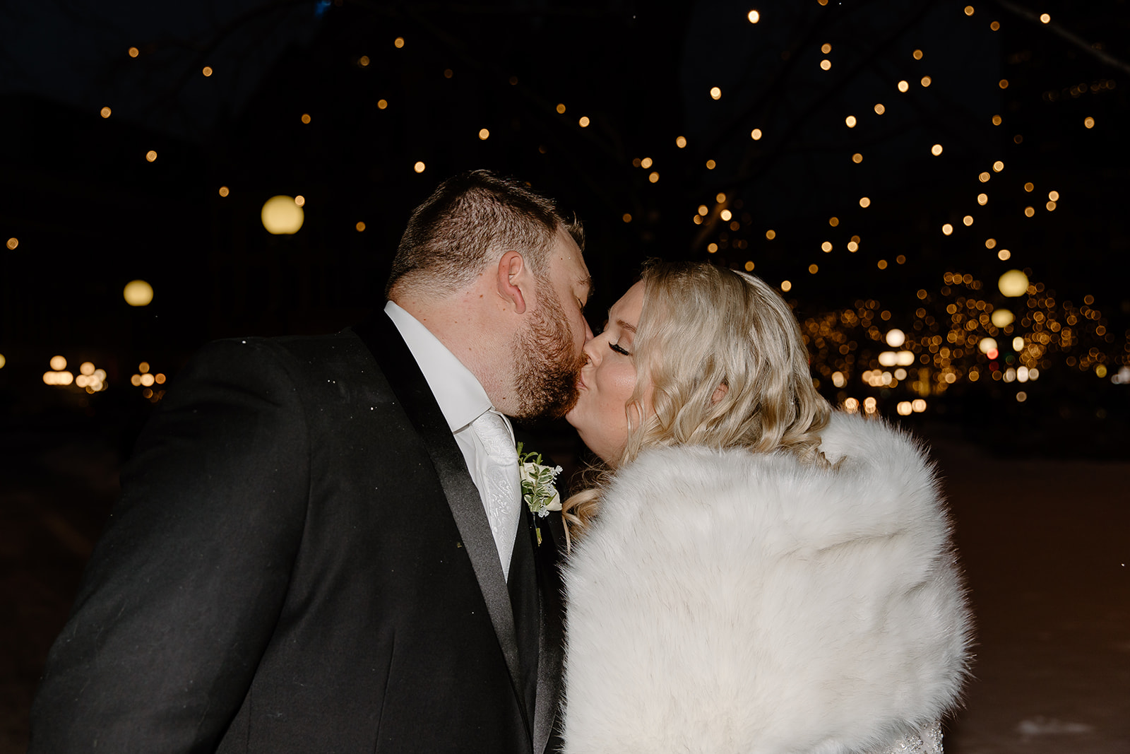 Bride and groom kissing in a snowstorm
