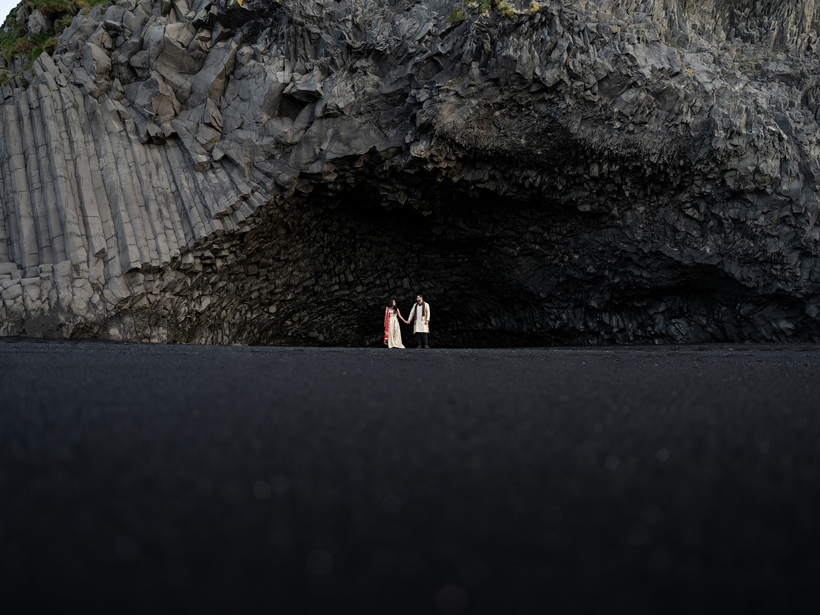 Couple standing in the cave at Black Sand Beach during their Elopement. 