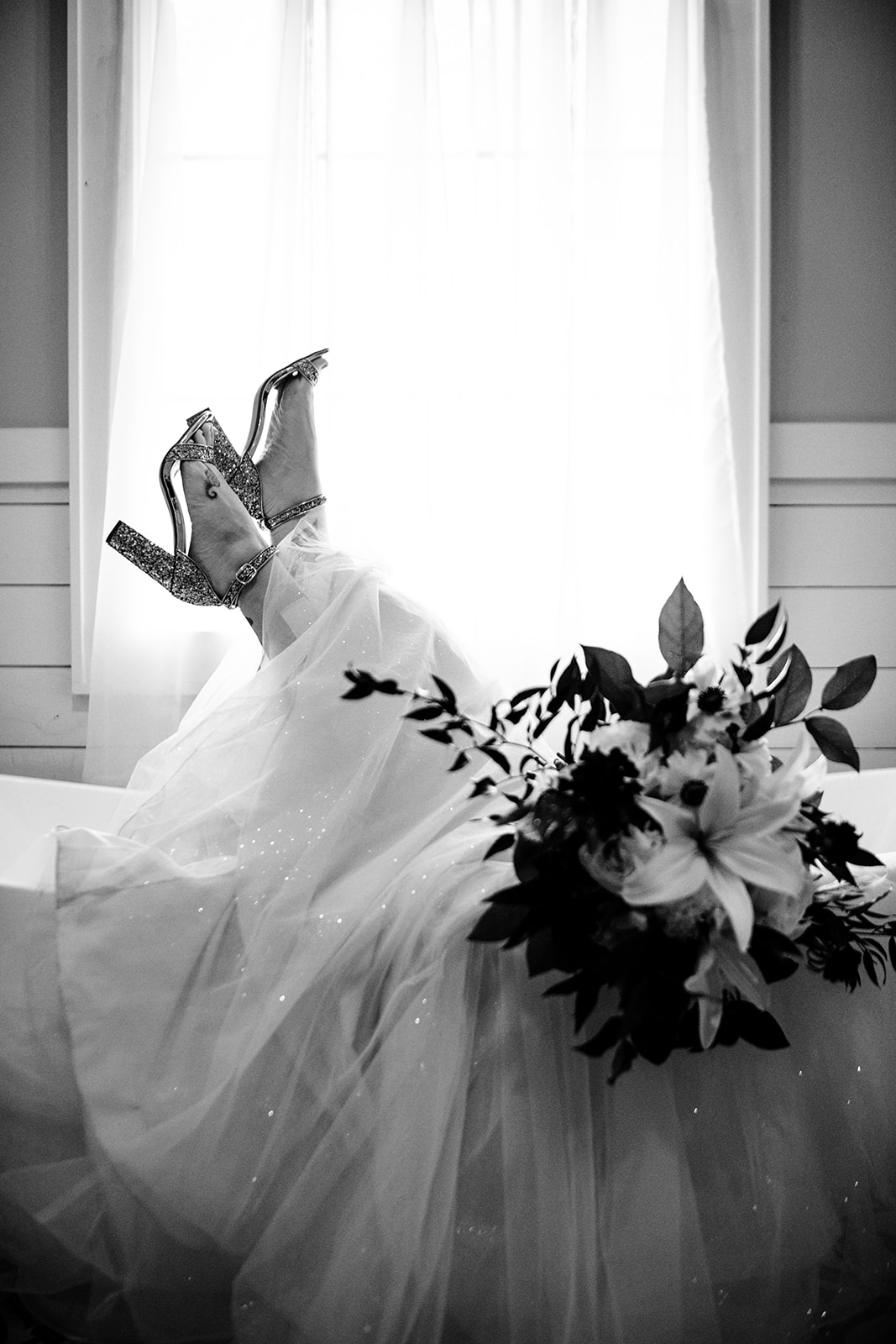 Bride laying in wedding dress inside bath tub at the parker, Mill bridal suite