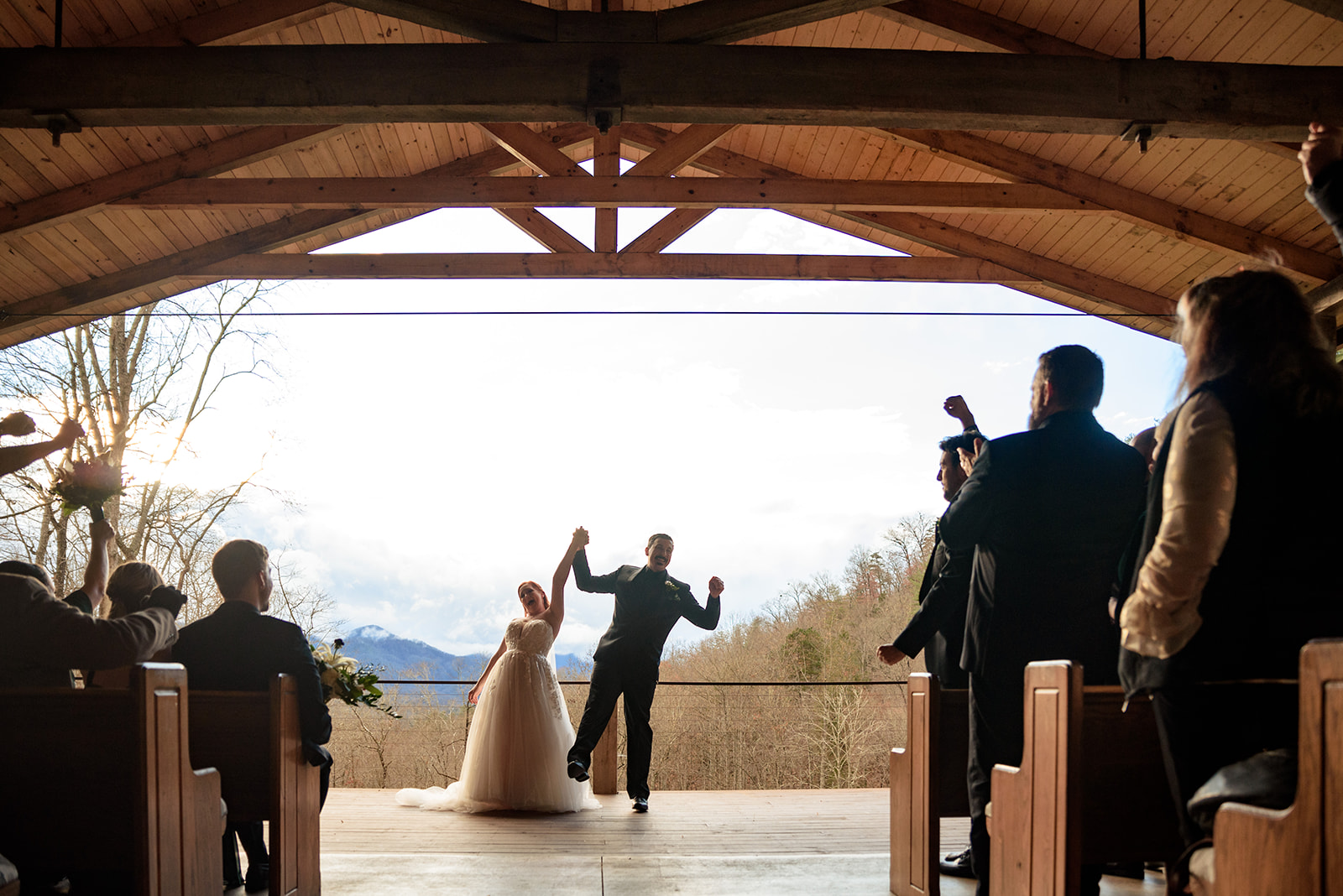 bride and groom sharing first kiss at parker mill with mountains in the background