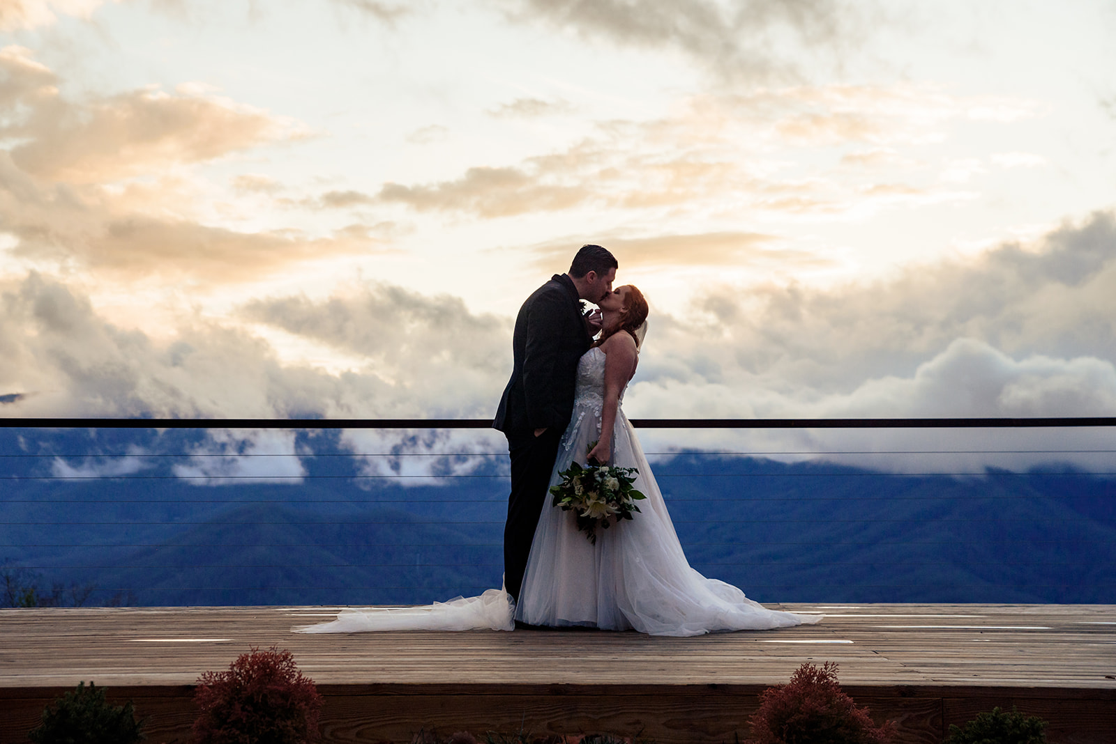 bride and groom wedding portraits at the summit of parker mill with clouds and mountains in the distance