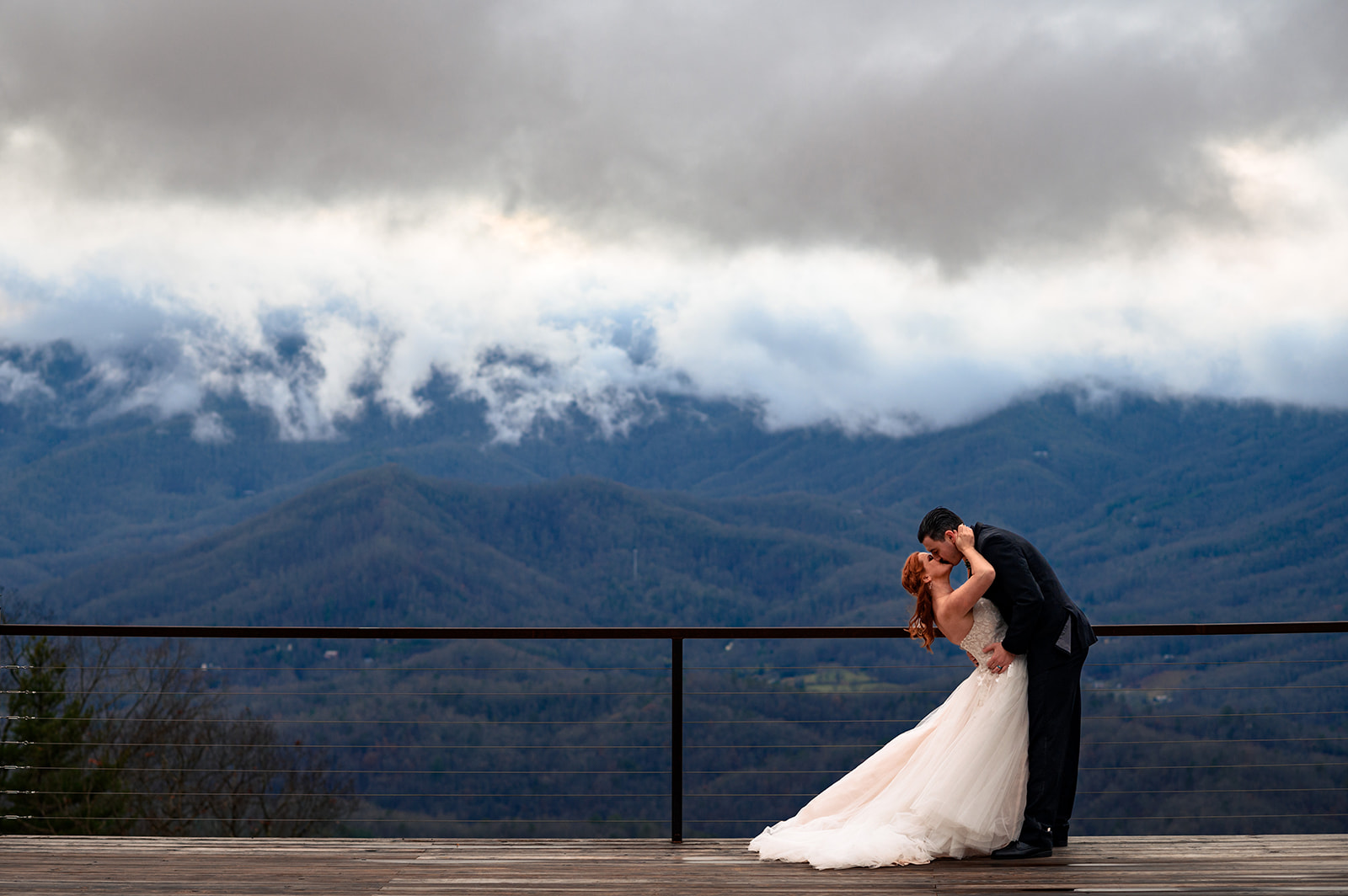 bride and groom wedding portraits at the summit of parker mill with clouds and mountains in the distance