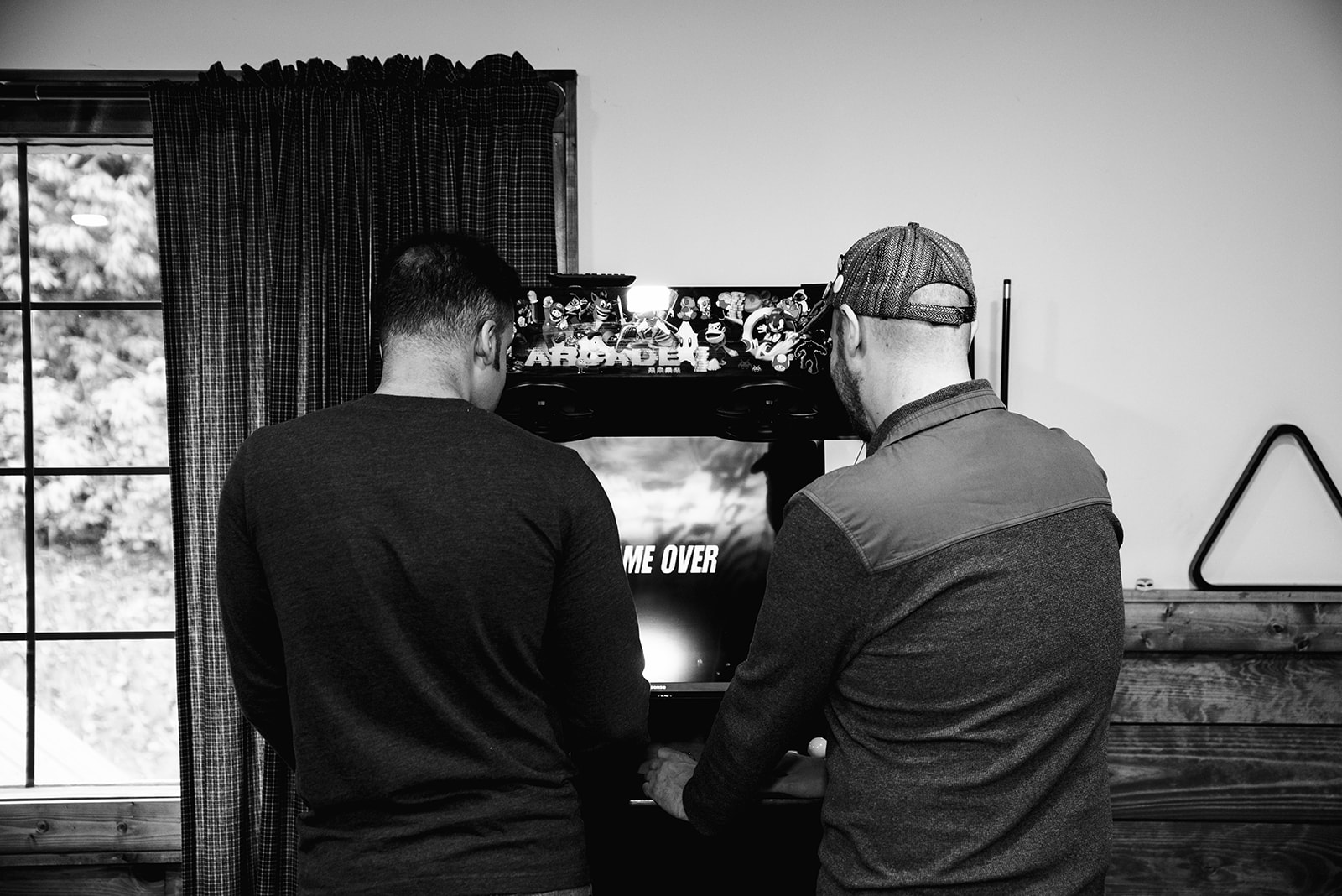 two groomsmen play a video game machine inside the groomsmen quarters at the parker mill