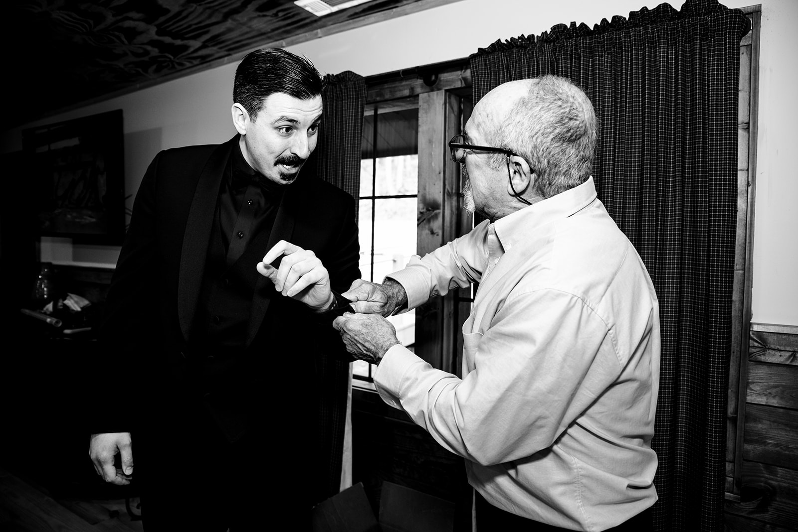 The uncle of the groom, putting cufflinks on the groom