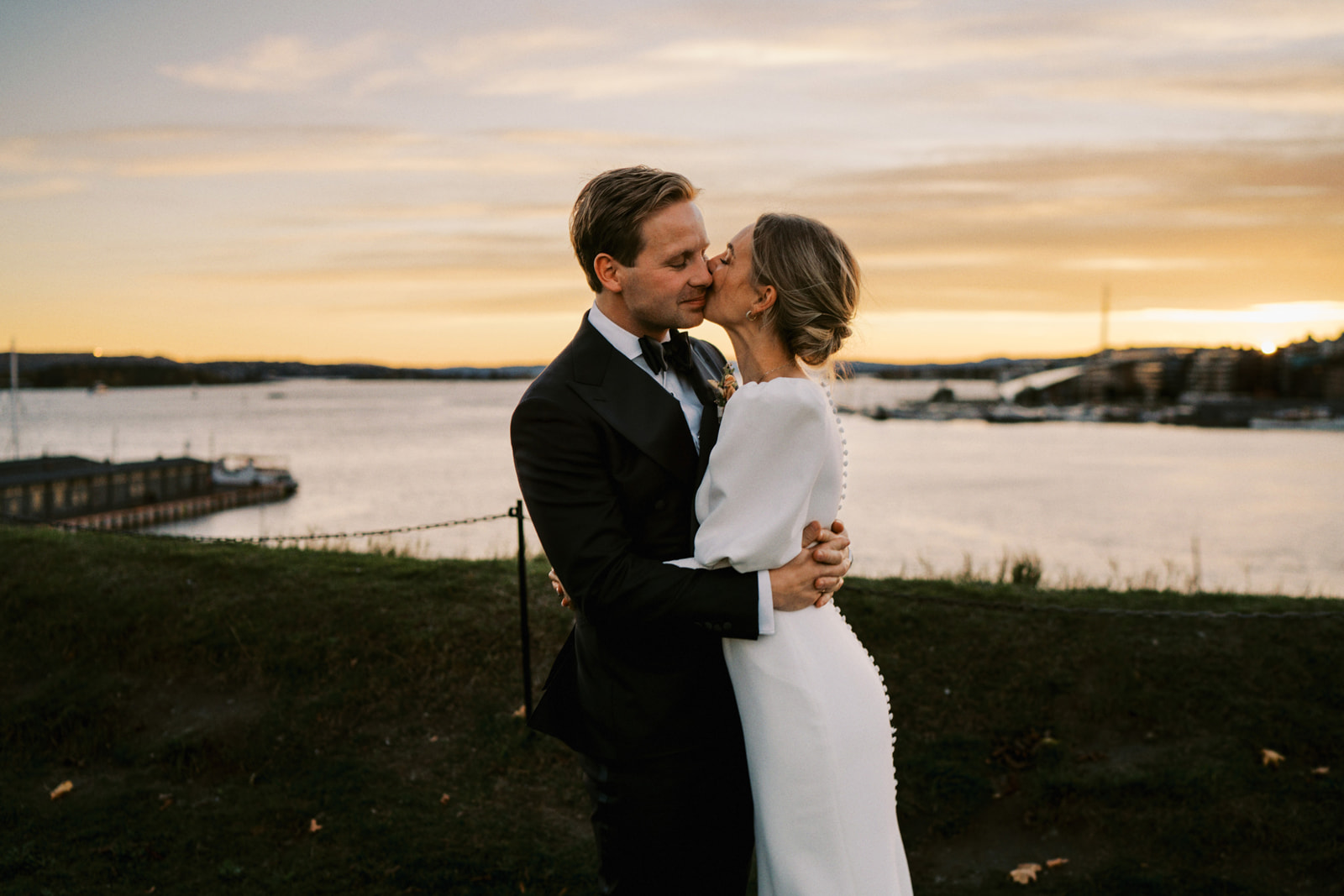 Brudepar i solnedgang på Akershus festning utsikt over Oslofjorden og Aker Brygge