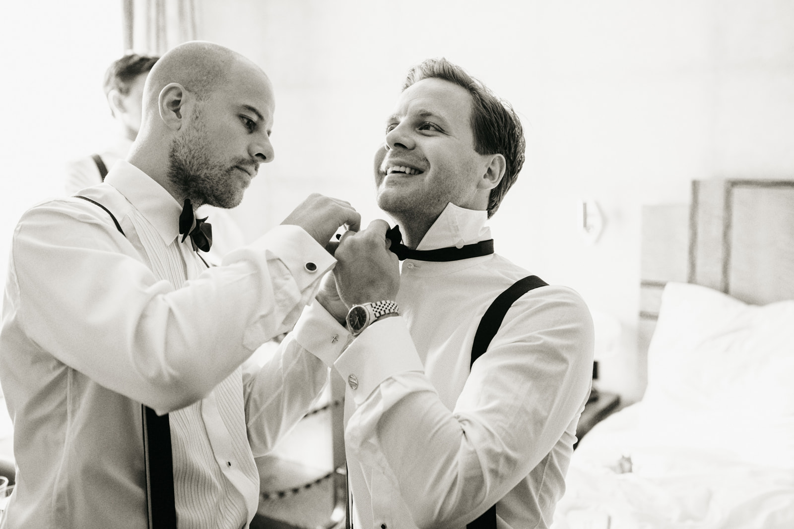 Groom getting ready for wedding day with help of best man