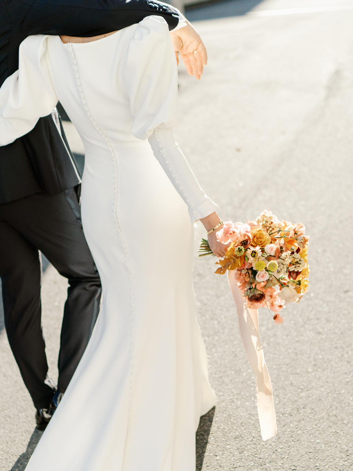 Sleek and modern dress detail shot with rust colored wedding  bouquet