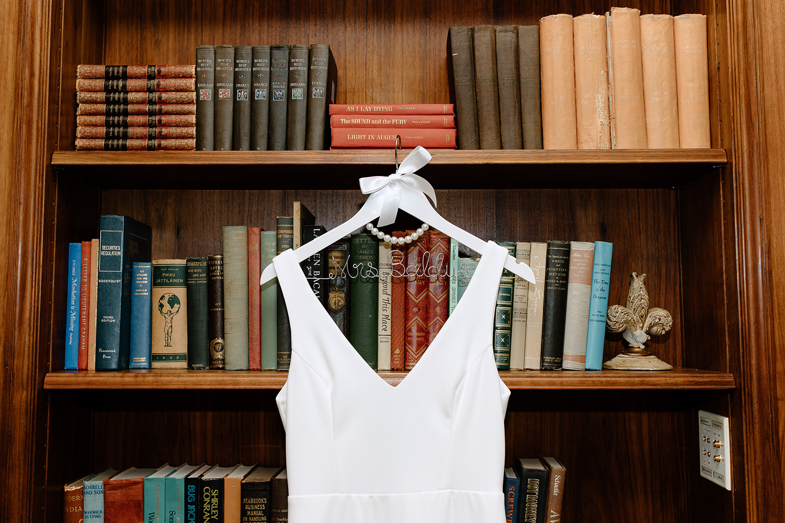 Wedding dress hanging from a bookshelf