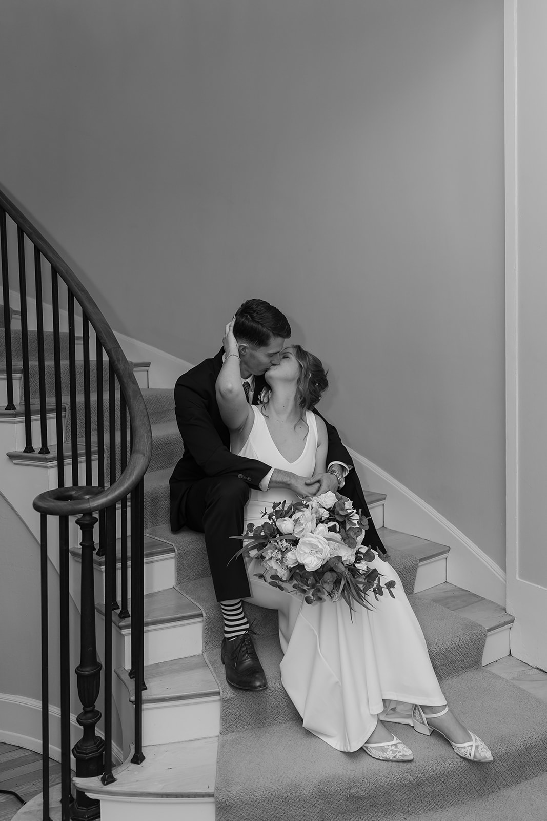Bride and groom sit on spiral staircase