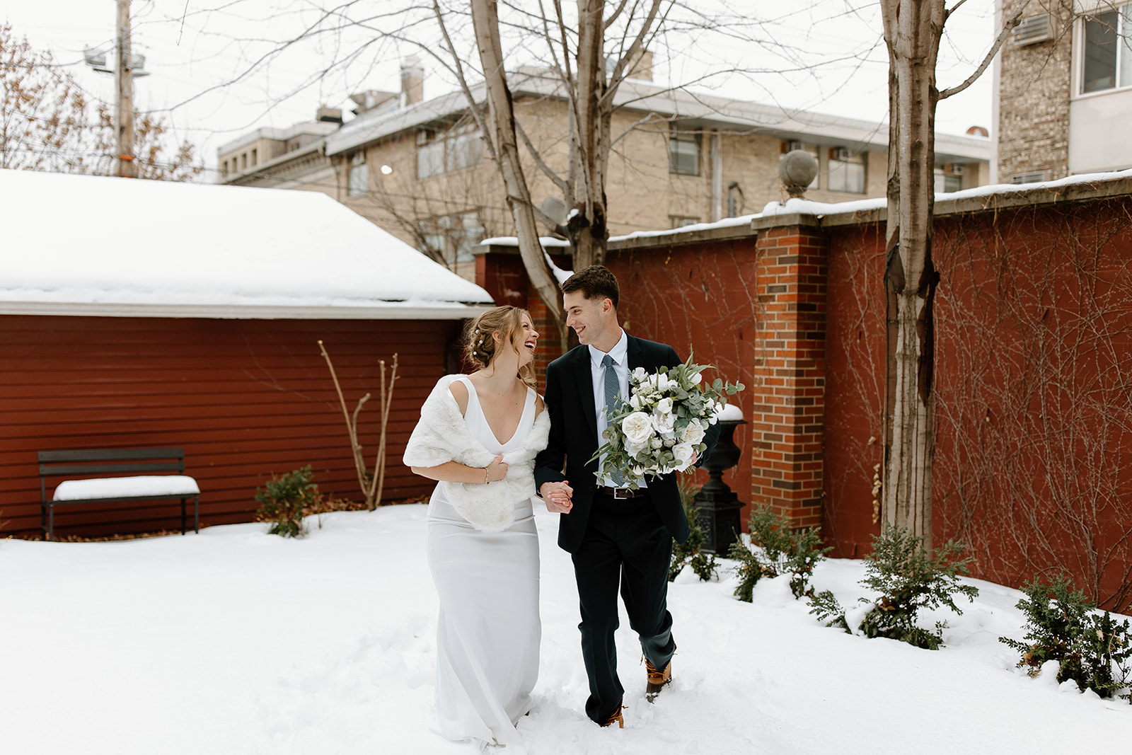 Bride and groom run through snow