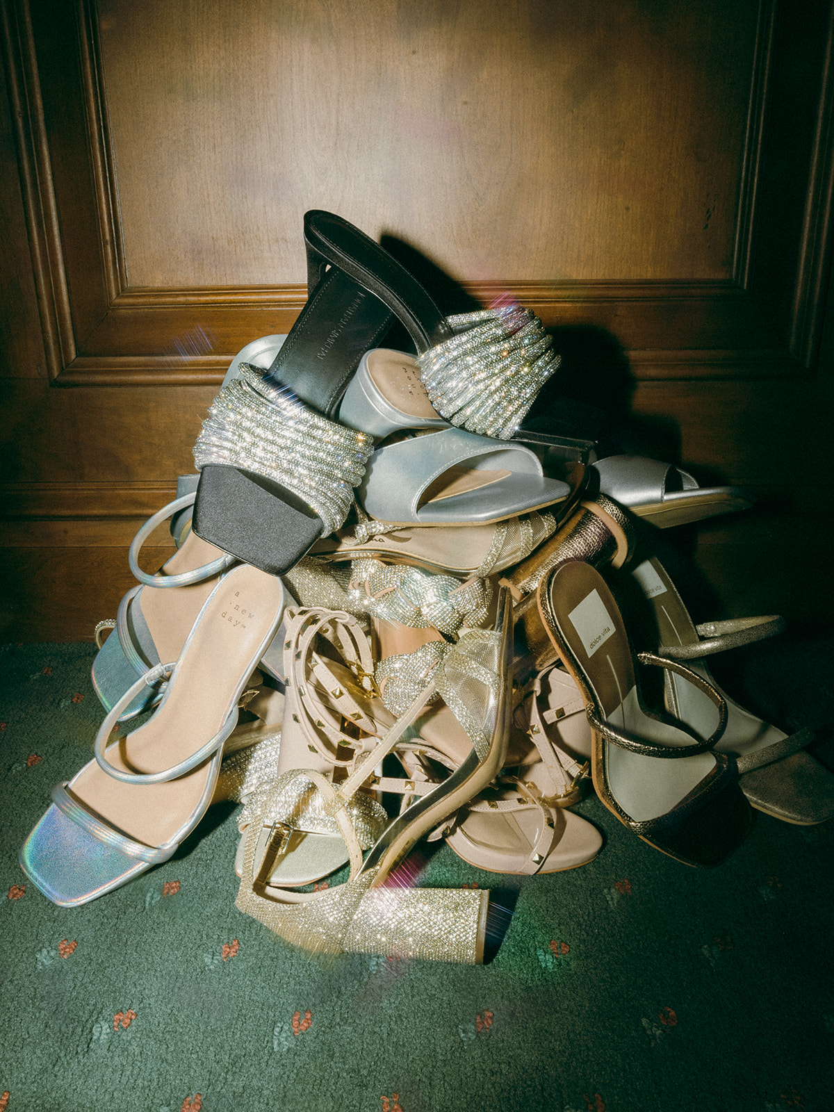 A stack of bridal party shoes with the bride's Jonathan Simkhai sandals on top.