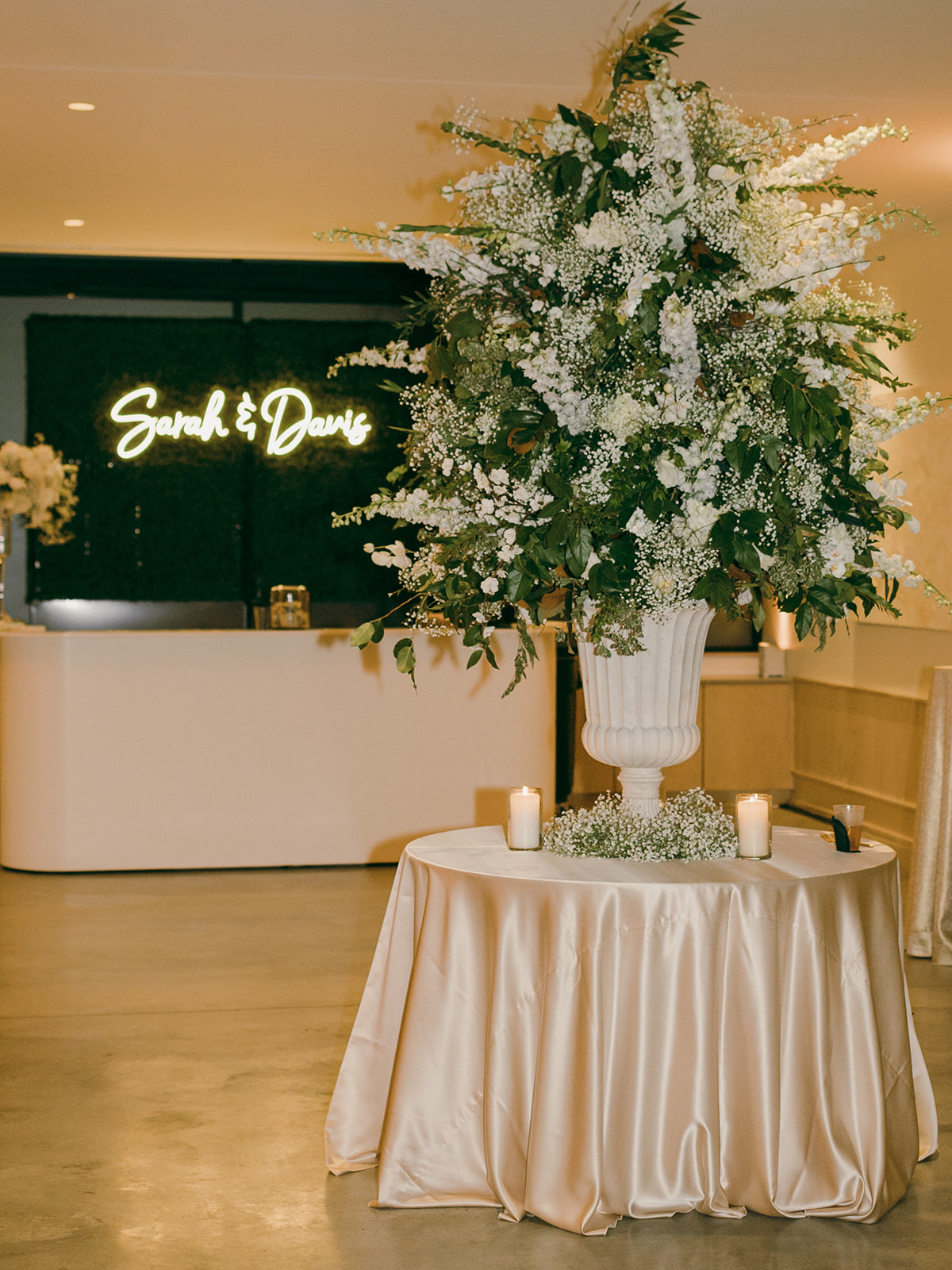 The bride and groom's custom neon sign hangs above the sleek white bar. 