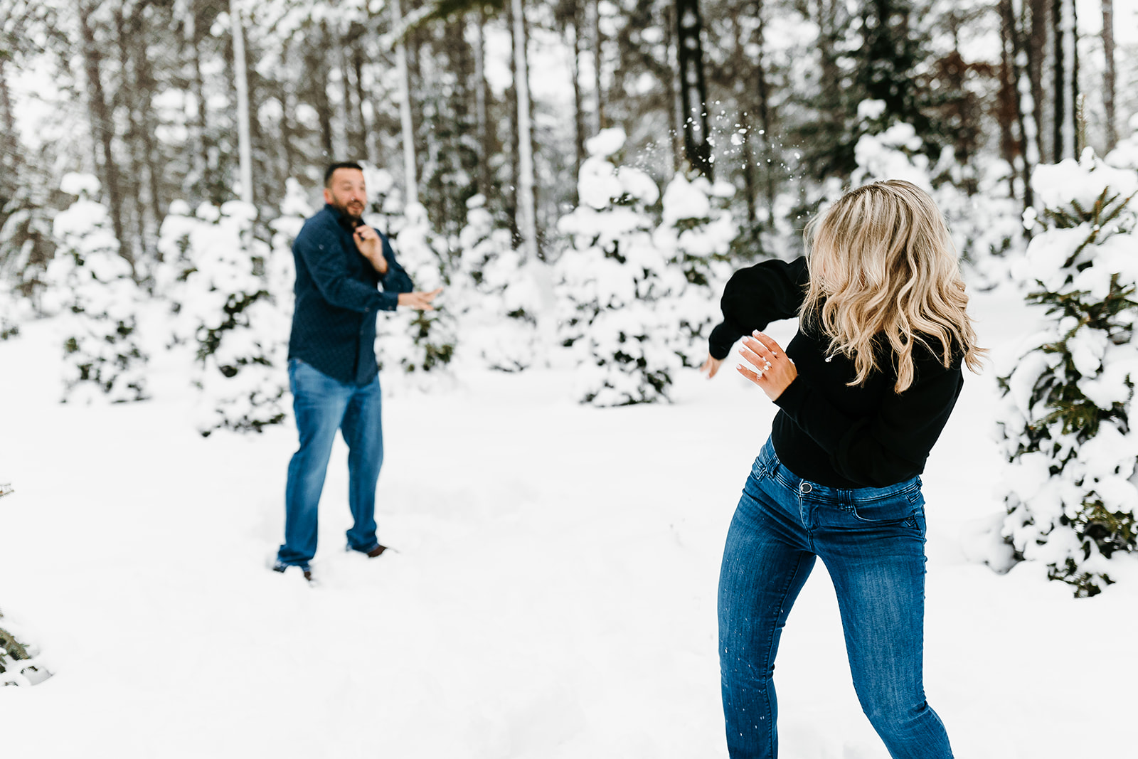 couple having a snowball fight in the snow