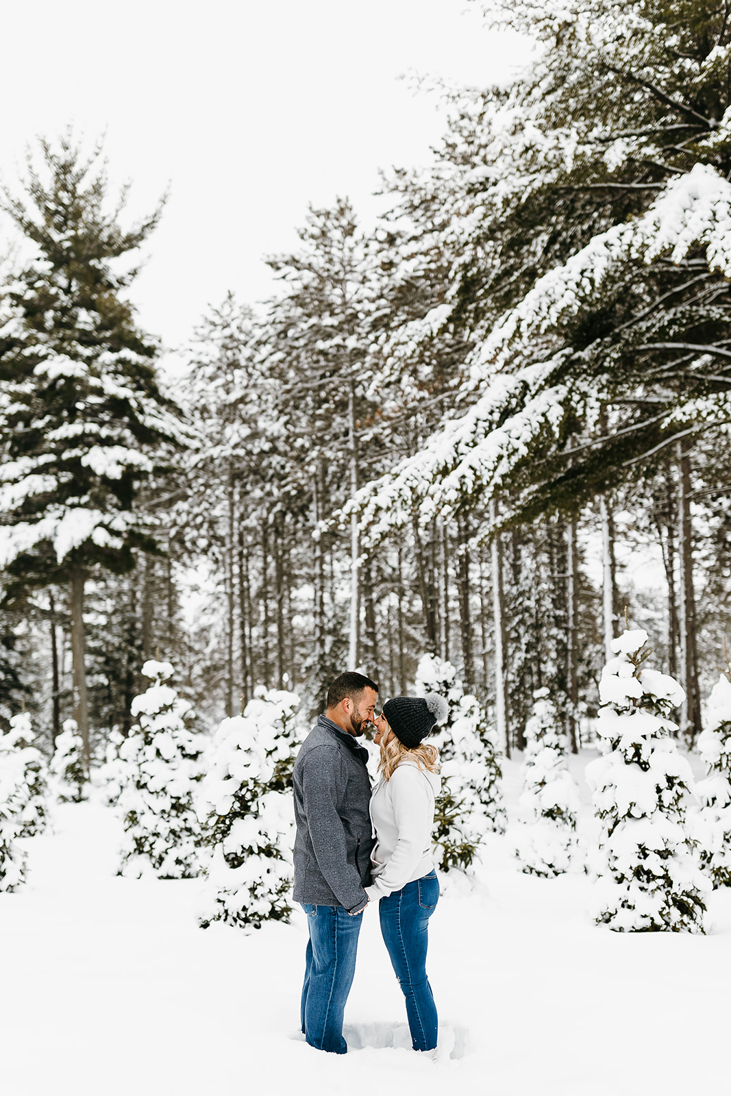 couple standing in snow kissing
