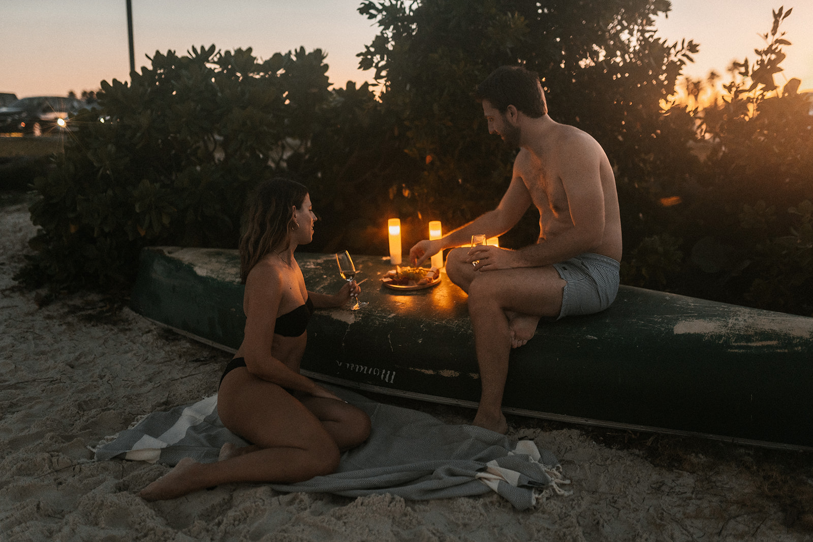 Couple having a romantic candlelit picnic by the beach in Miami Beach.