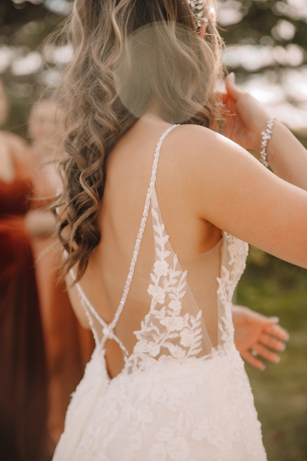 Detail photo of bride's open back, lace wedding dress with thin straps