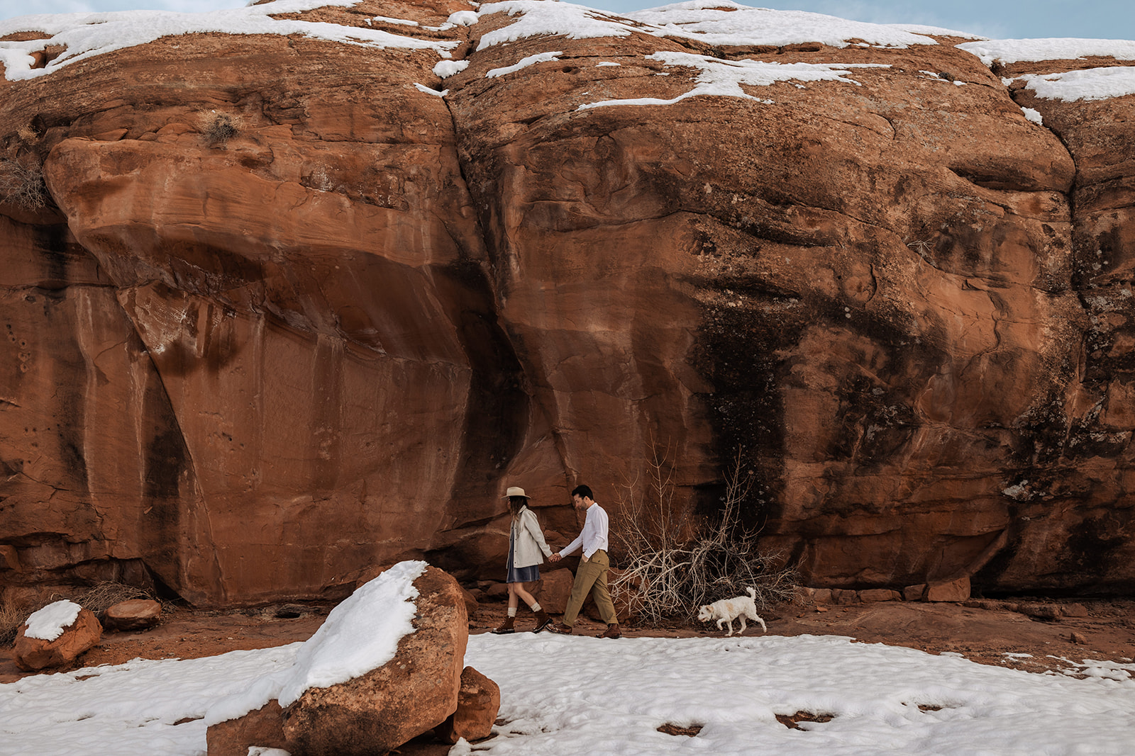 couple hiking with their dog in moab, utah