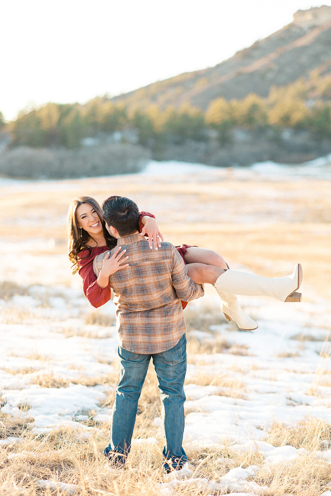 Groom picking bride up in engagement portrait in mountain setting