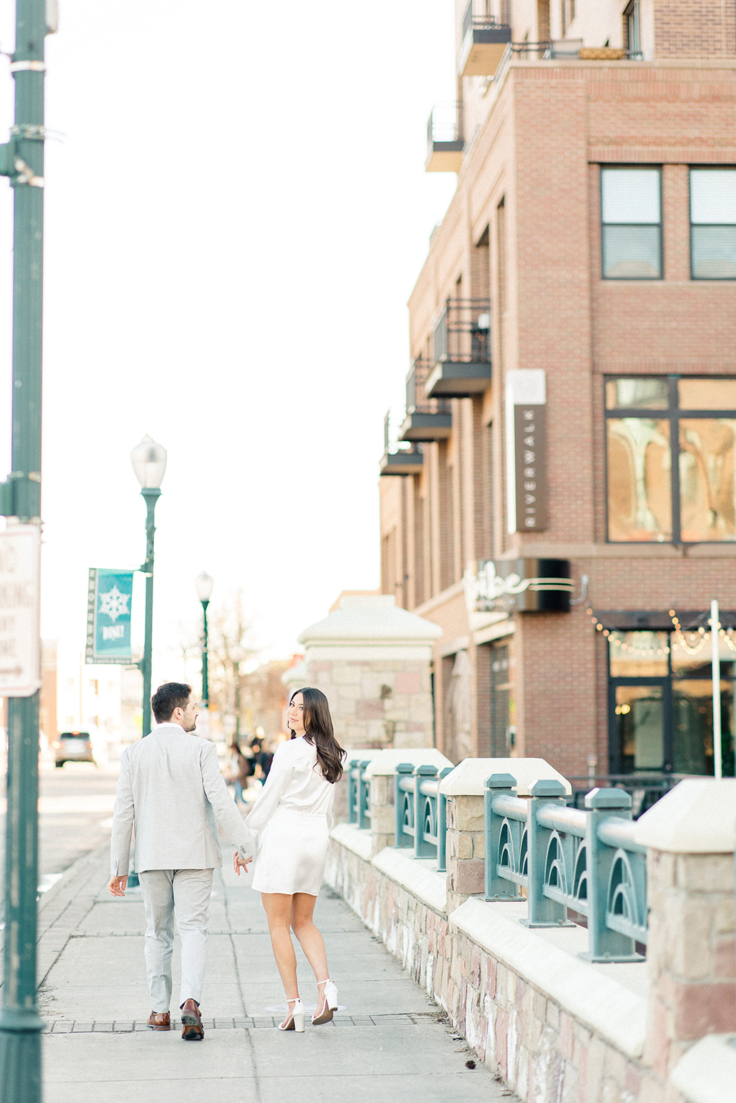 Couple walking away from camera, bride looking back in Castle Rock 