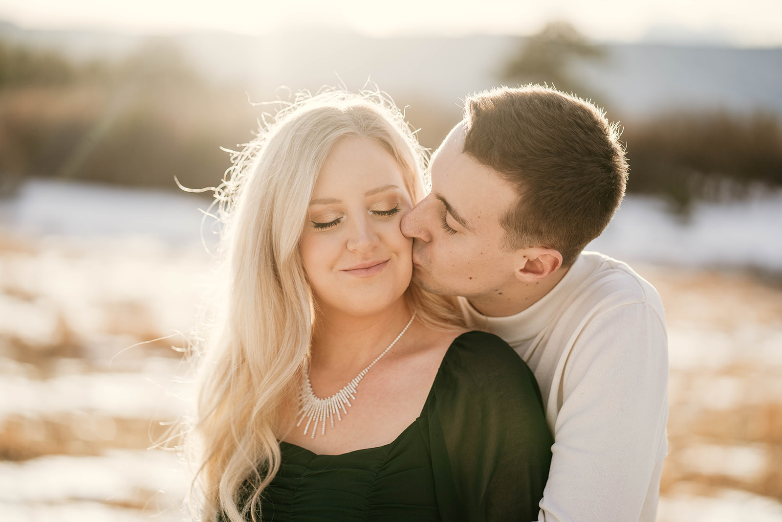 Golden hour engagement session in grassy field with beautiful mountain views in Castle Rock, Colorado