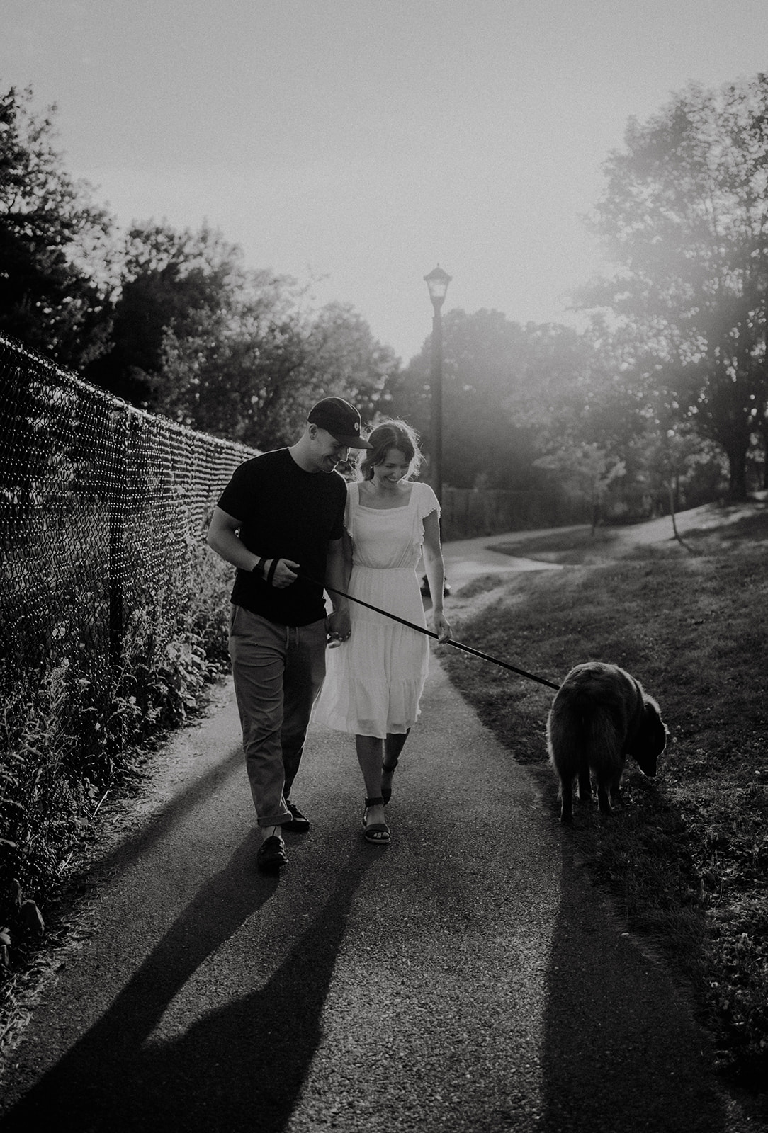 black and white photo of engaged couple walking on trail at Dartmouth waterfront Harbourfront trail