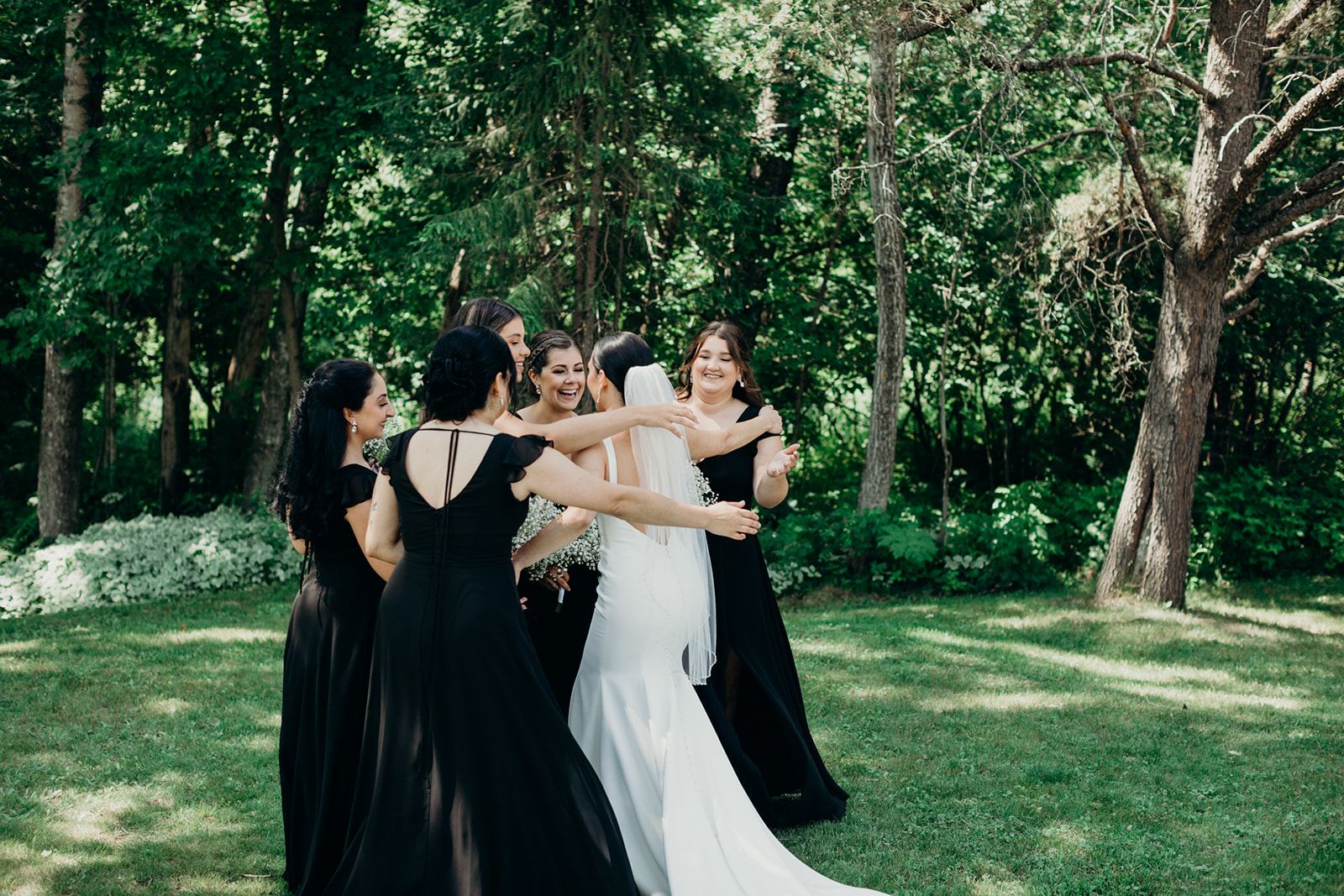 Bridesmaids hug after their first look with the bride