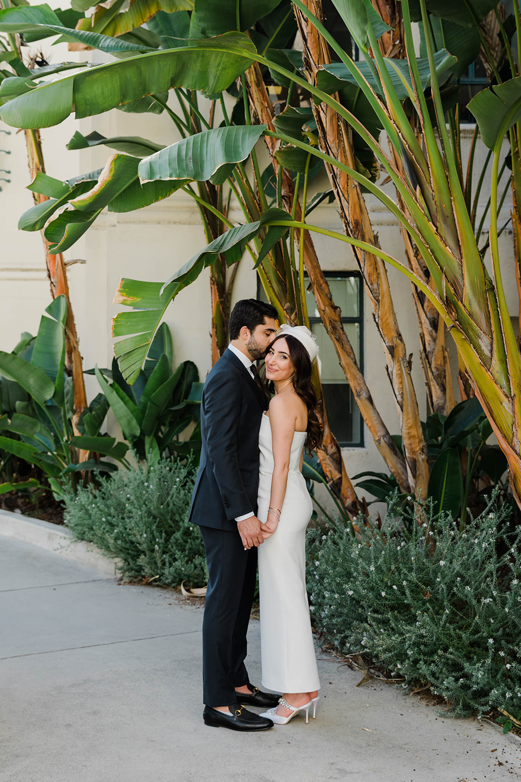 A couple getting close in front of a beautiful palm tree at Beverly Hills City Hall