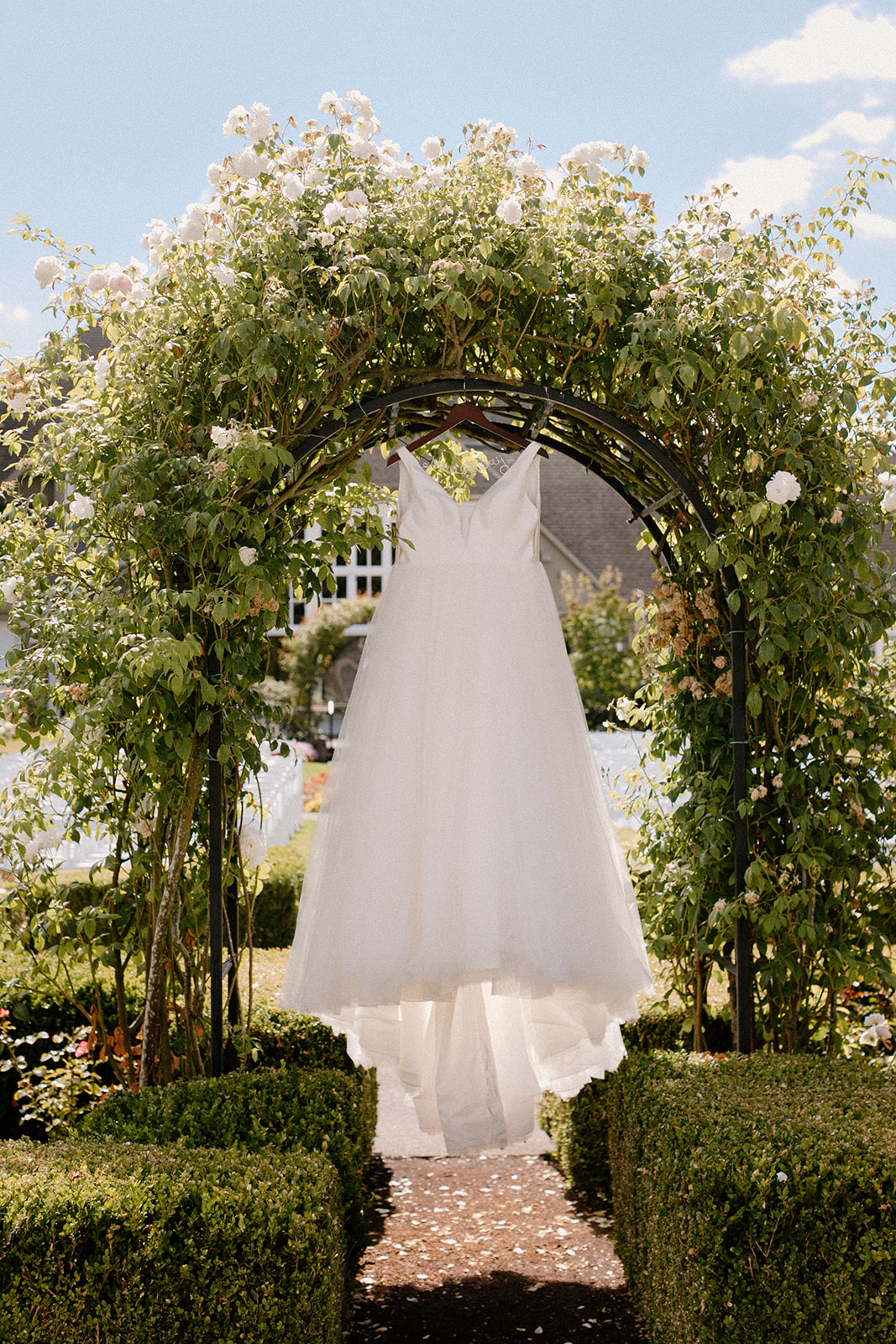 a wedding dress hanging at the rose arbor at an Oregon Golf Club wedding.