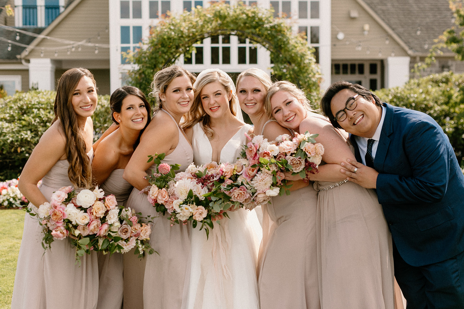 Bridesmaids embrace outside at in the rose garden at the Oregon Golf Club. 
