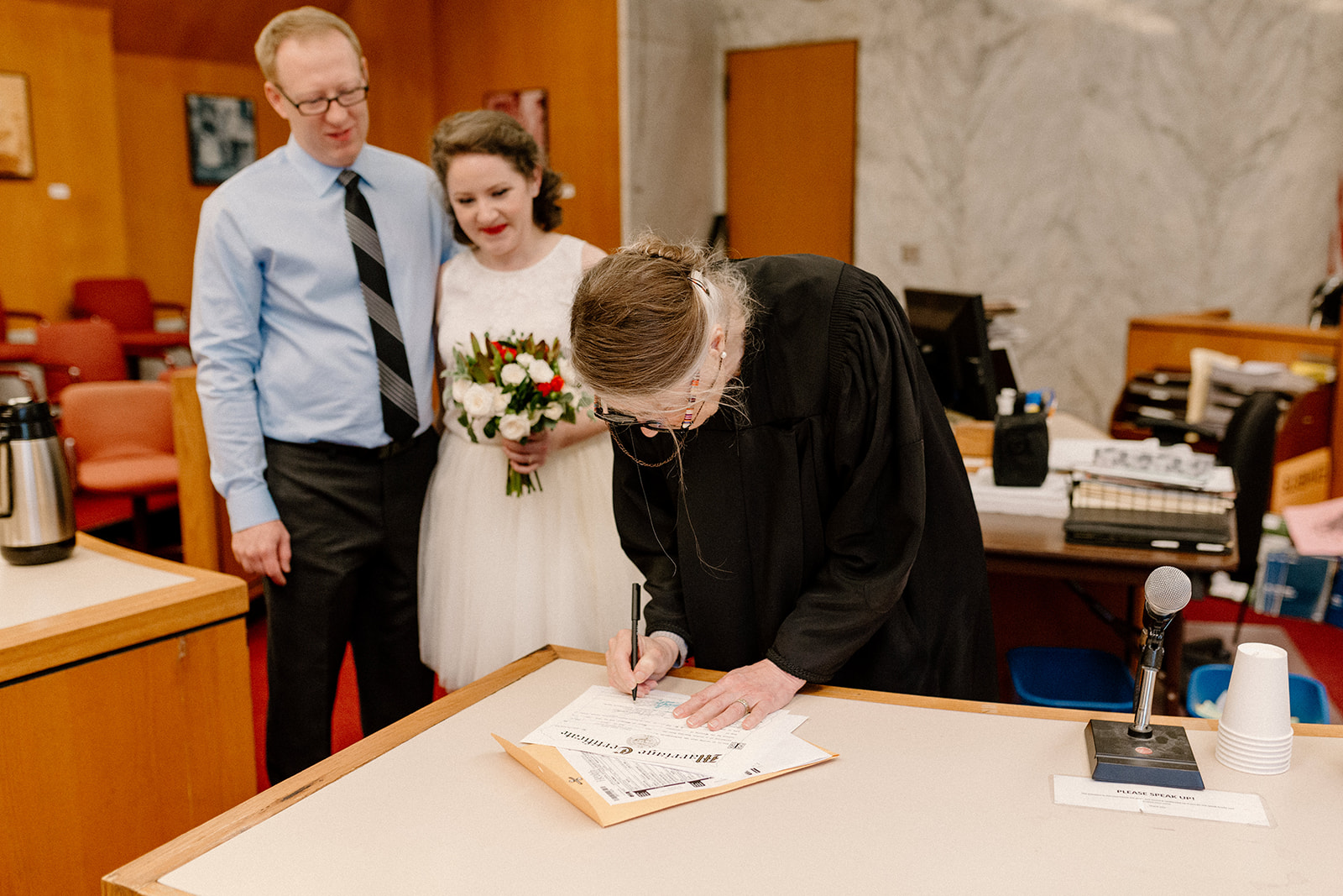 A judge signs a marriage license at a Portland courthouse elopement. 