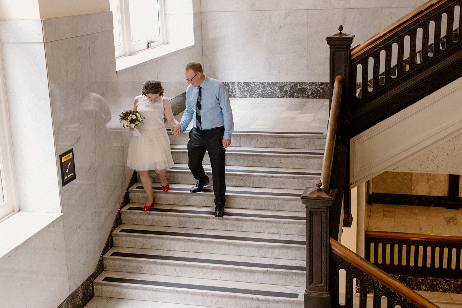 A bride and groom taking wedding photos at the Multnomah County courthouse. 