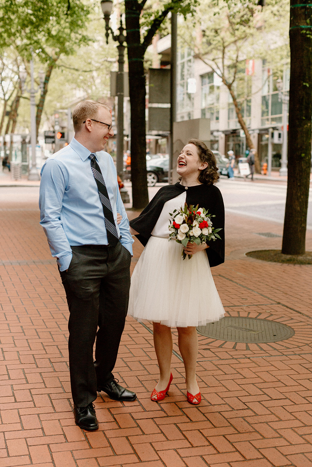 A bride and groom taking photos in downtown Portland before their courthouse elopement. 