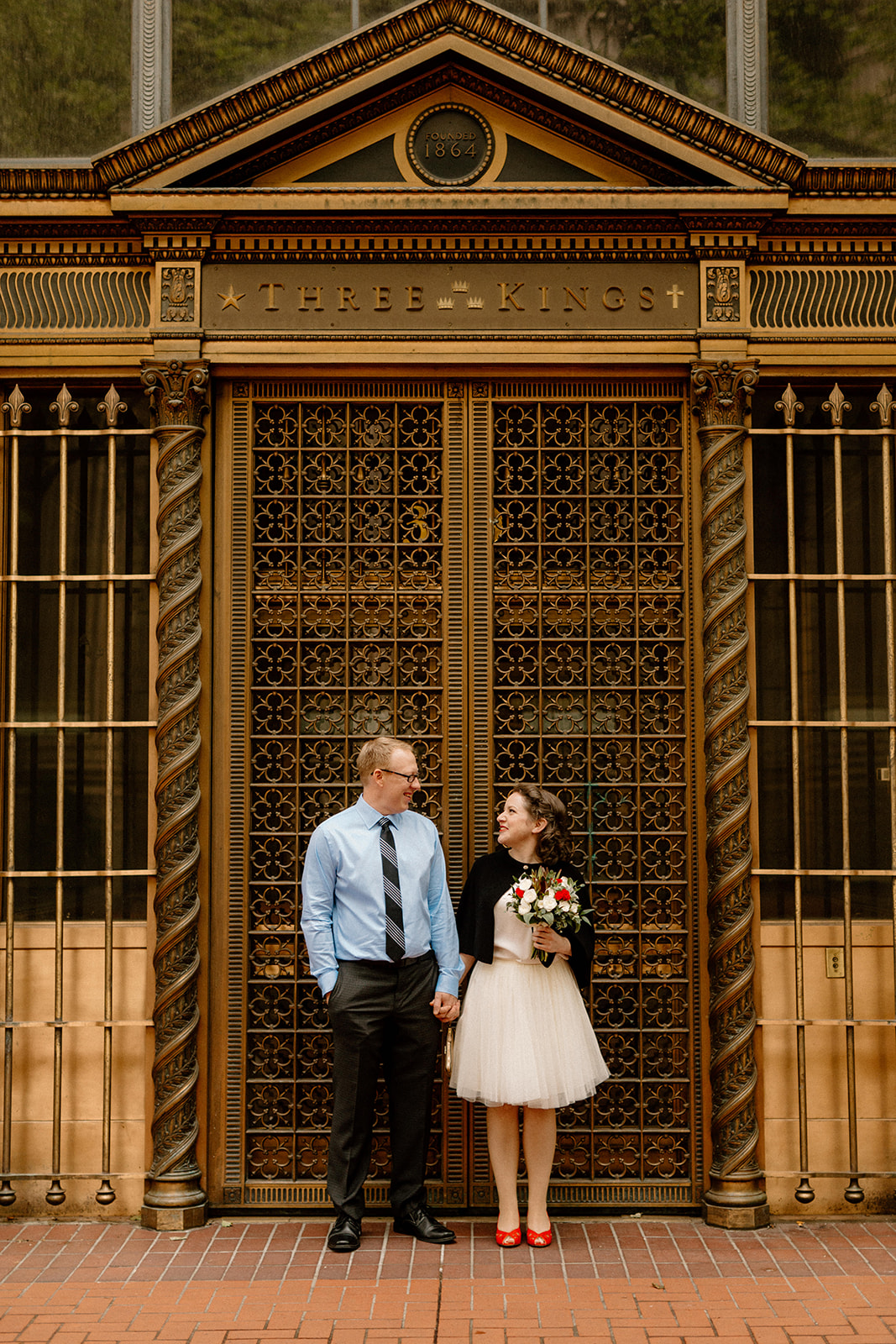 A bride and groom taking photos in downtown Portland before their courthouse elopement. 