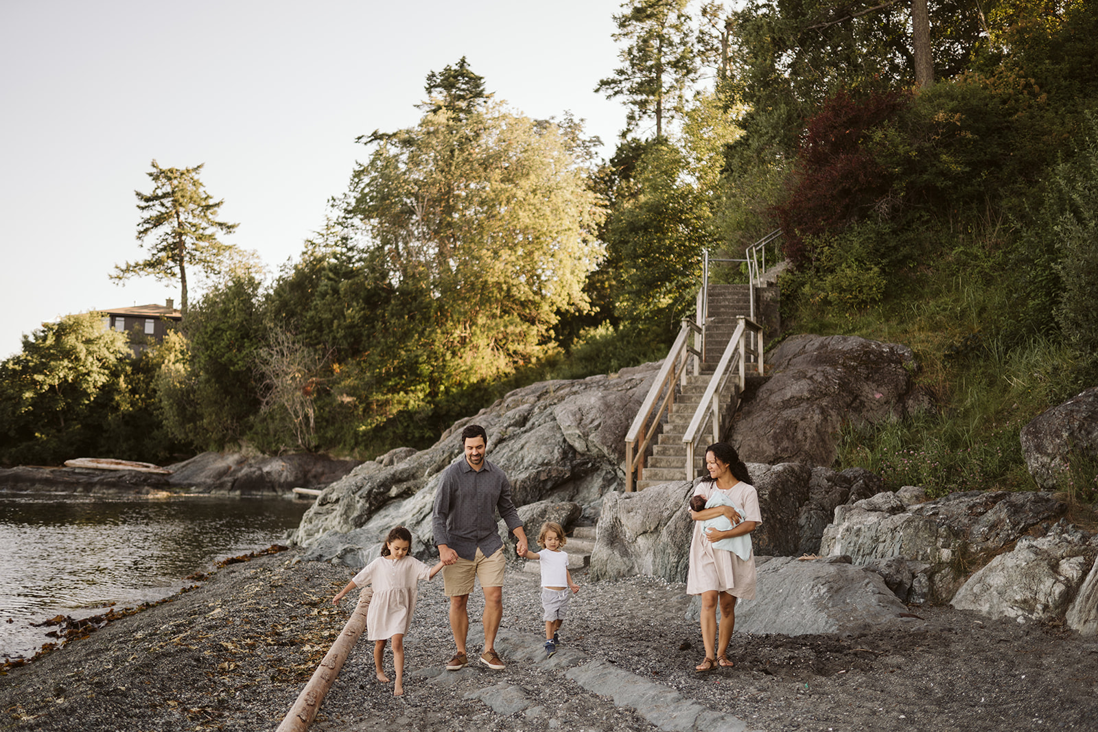 Family of five walking on a rocky beach