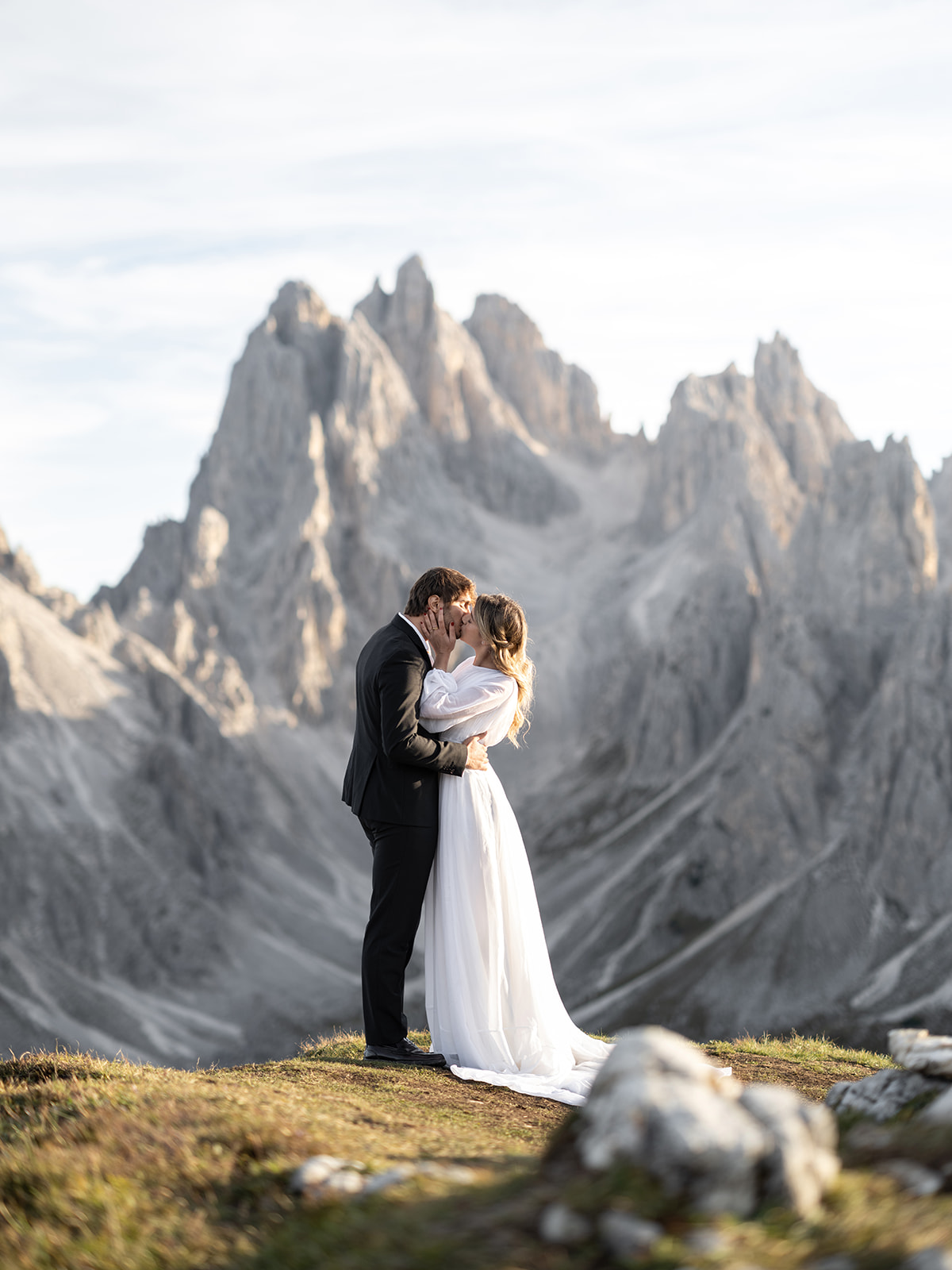 bride and groom kissing with the dolomites in the background on their wedding day 