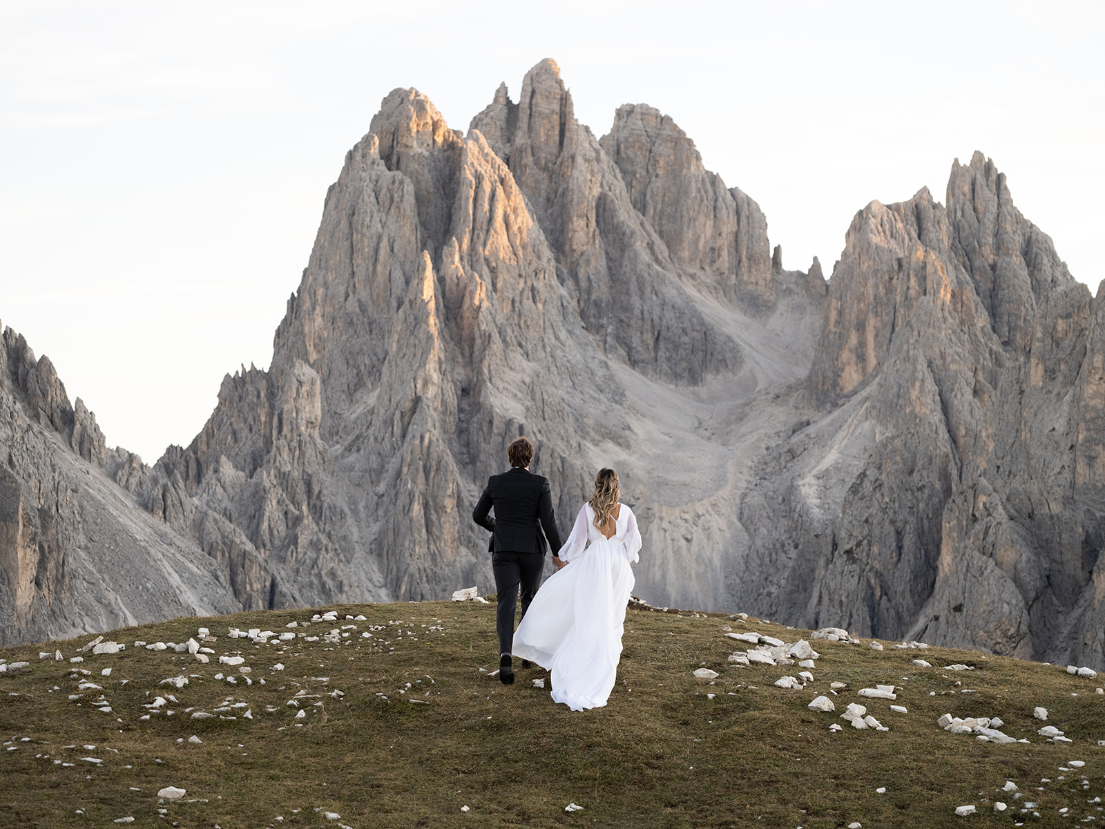 bride and groom running at the dolomites during their elopement 