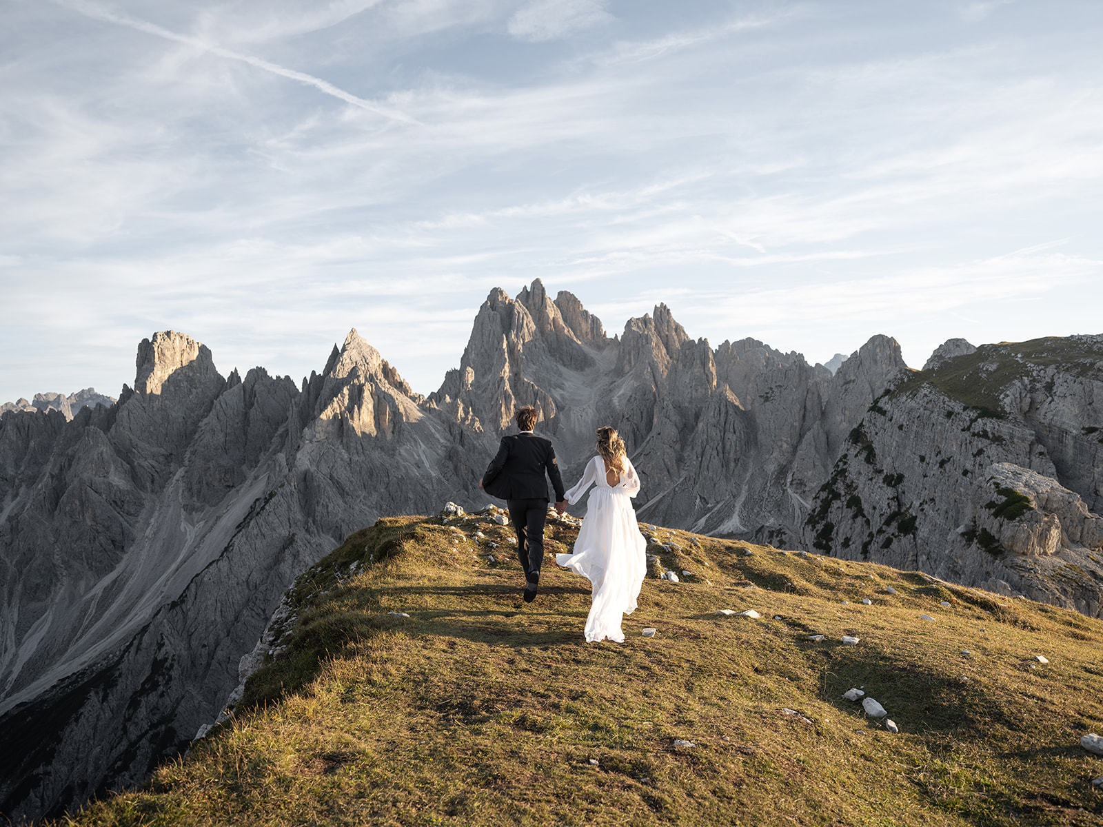bride and groom running in the dolomites Italy 